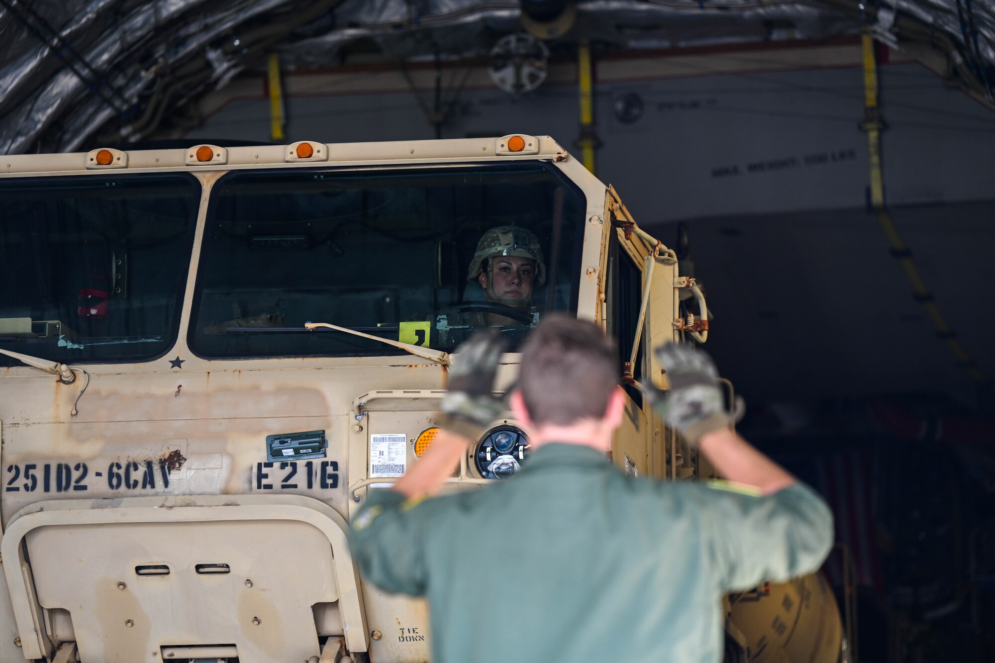 U.S. Air Force Staff Sgt. Cory Dye, 535th Airlift Squadron loadmaster, directs a Heavy Expanded Mobility Tactical Truck on a C-17 Globemaster III support of a Maui wildfire humanitarian aid and disaster relief on the island of Maui at Joint Base Pearl Harbor-Hickam, Hawaii, August 19, 2023. Members from the 535th AS transported U.S. Soldiers to the island of Maui to help those impacted by the wildfires and to provide aid and disaster relief to the impacted communities. (U.S. Air Force photo by Senior Airman Makensie Cooper)
