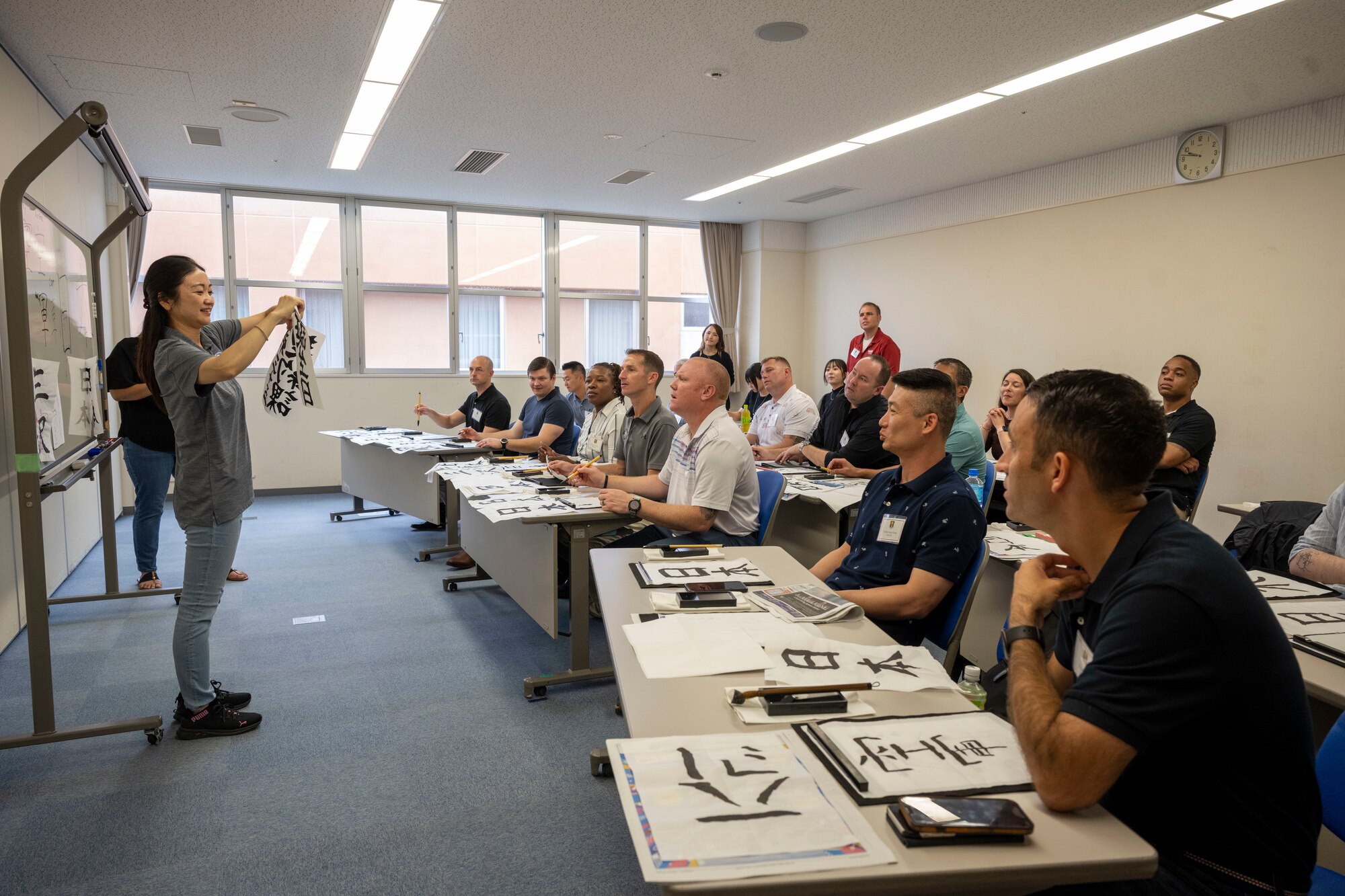 Commanders and senior enlisted leaders assigned to the 35th Fighter Wing practice calligraphy together during a team building event at the Misawa International Center.