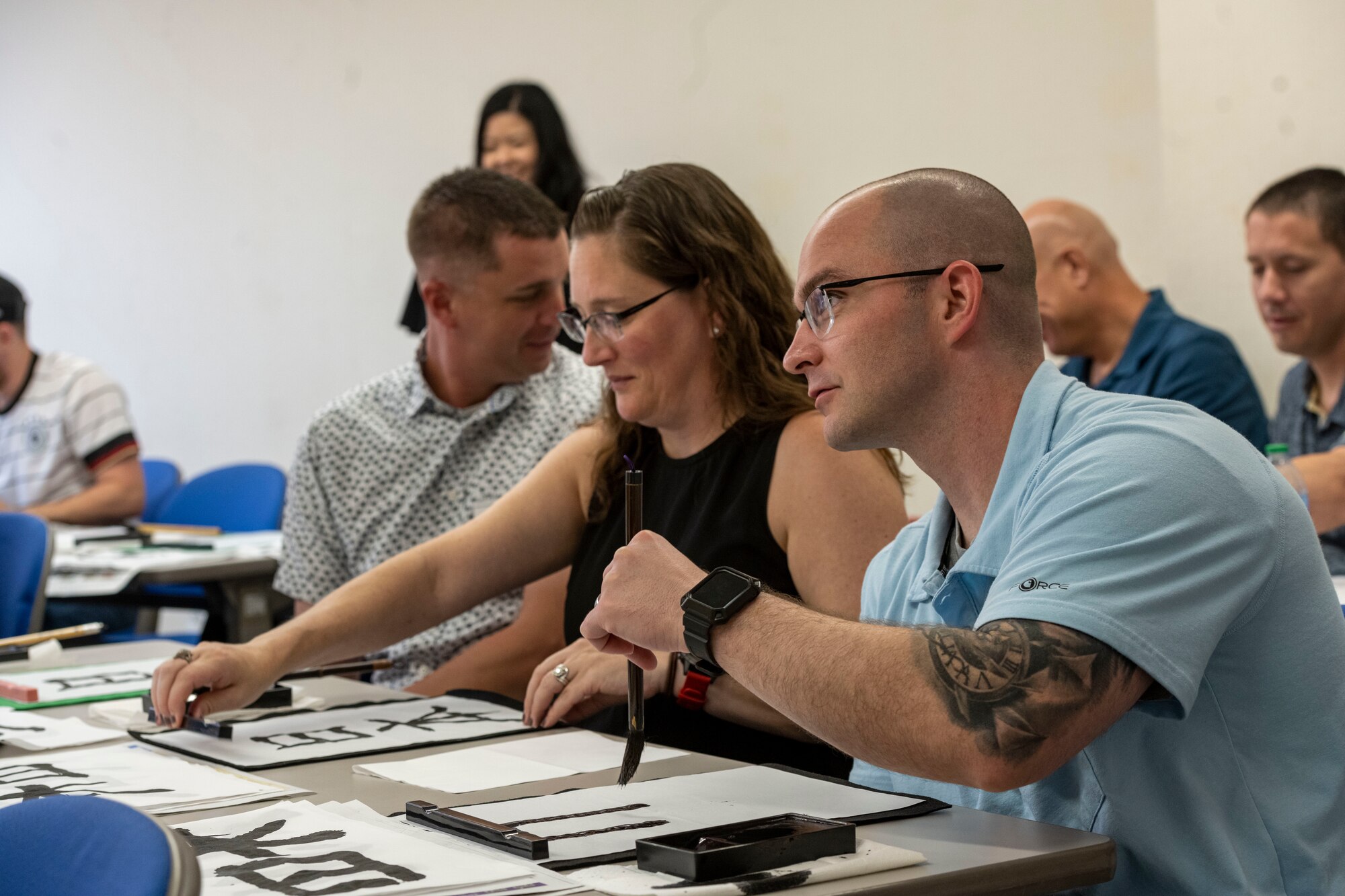 Commanders and senior enlisted leaders assigned to the 35th Fighter Wing practice calligraphy during a team building event at Misawa International Center.