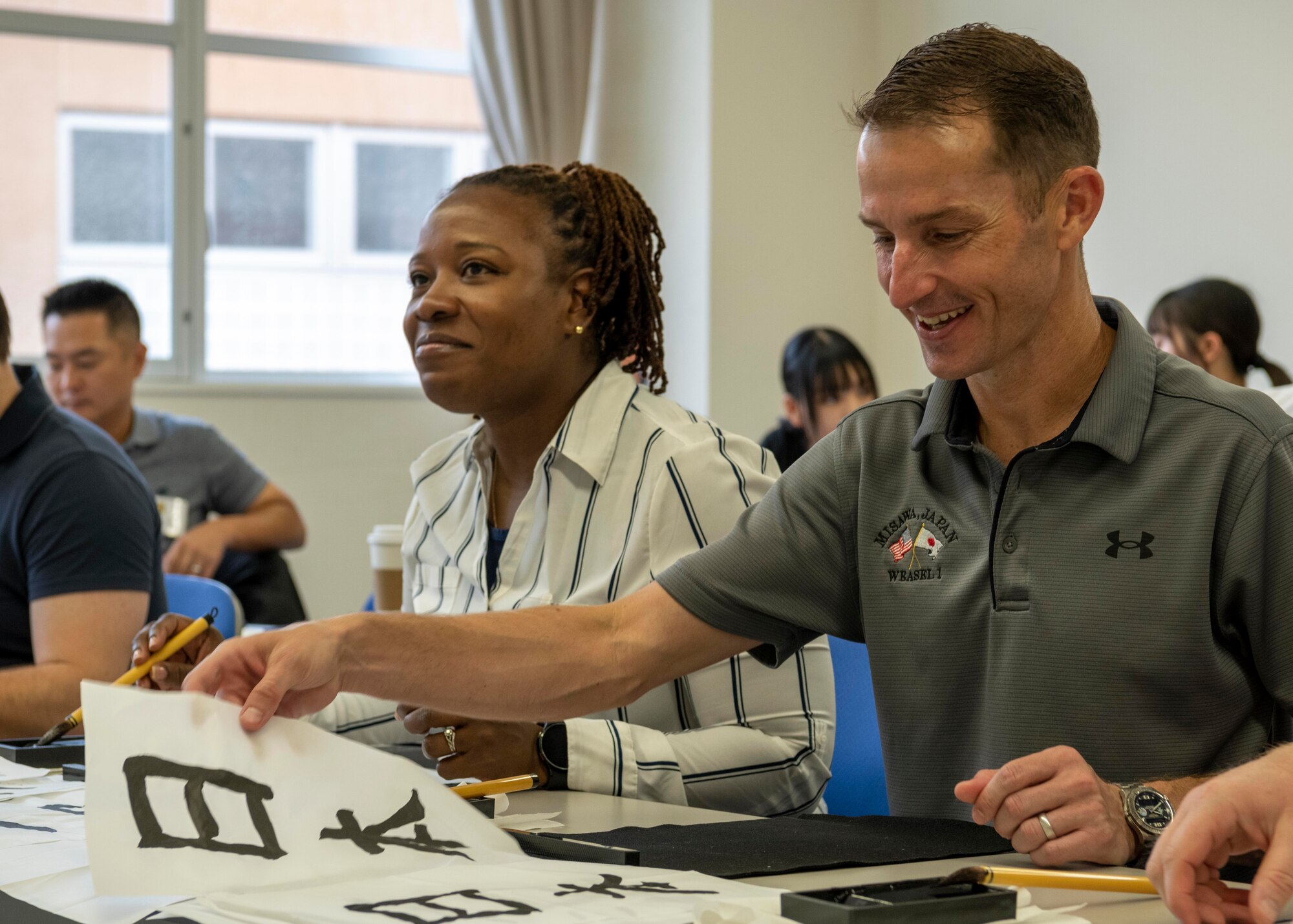 U.S. Air Force Col. Michael Richard, 35th Fighter Wing commander, and other attendees practiced calligraphy during a team building event held at the Misawa International Center.
