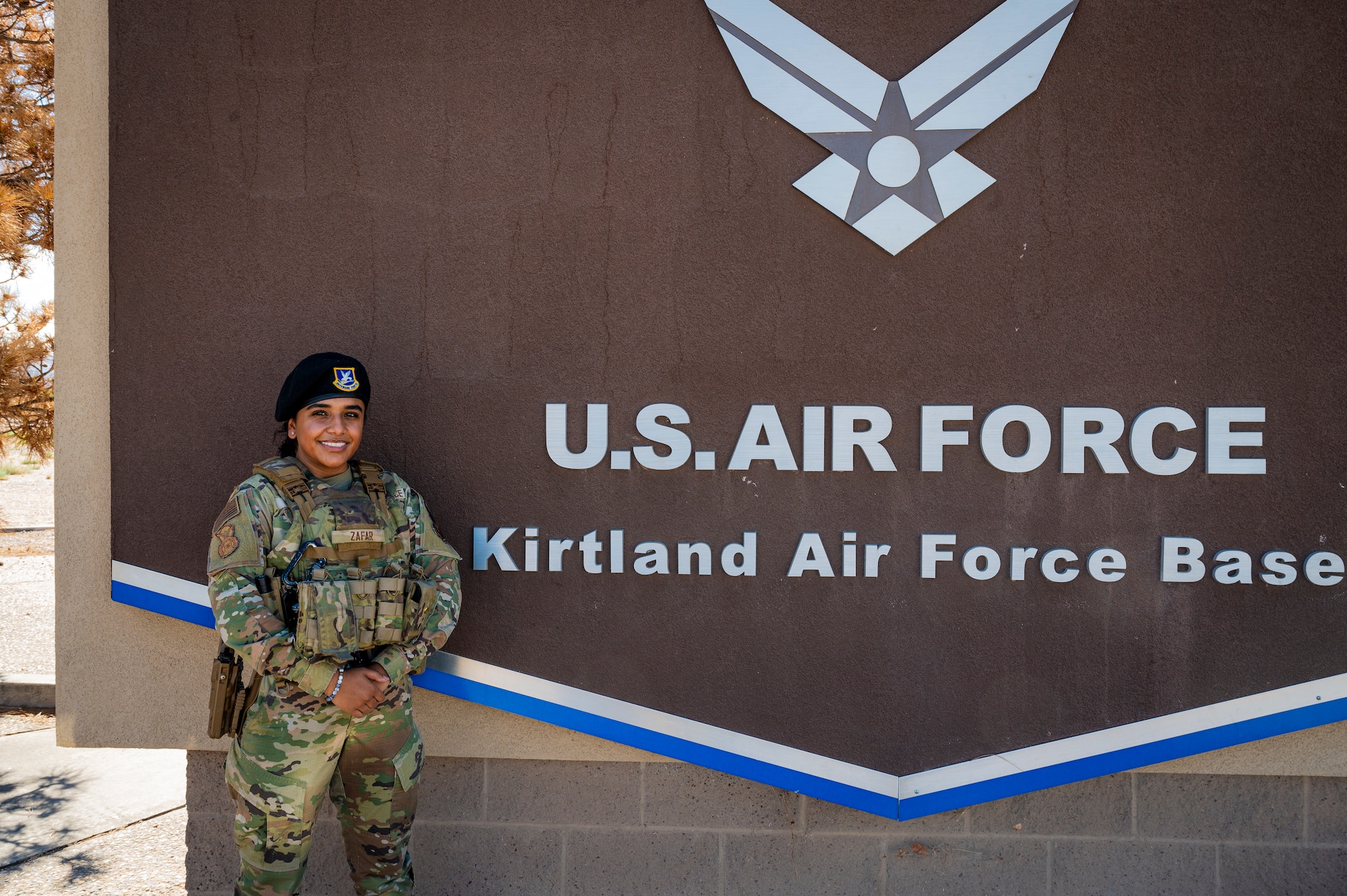 A woman poses in front of a sign.