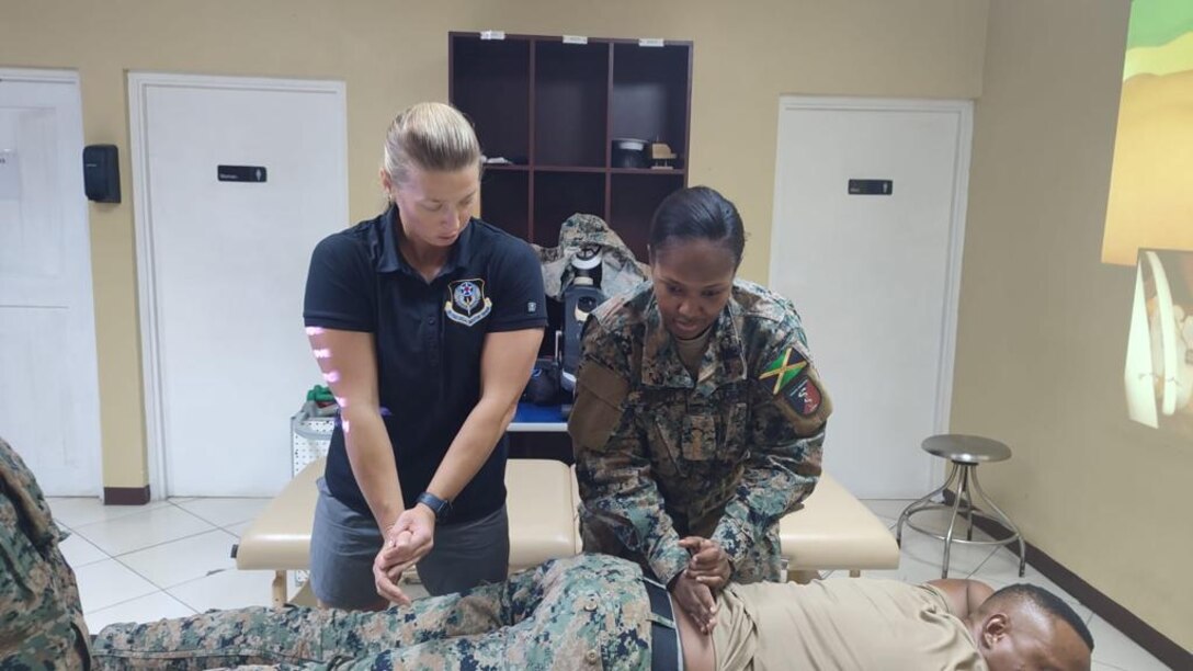 Maj. Joanna Borawski, the IRON Physical Resilience branch chief from the 1st Special Operations Wing at Hurlburt Field, Fla., demonstrates physical therapy techniques alongside a Jamaican military physical therapy technician as part of a collaborative healthcare visit at the Jamaica Defense Forces Medical Center in Kingston. This Embedded Health Engagement Team shared best practices to help boost Jamaica’s military medical readiness, strengthening relationships and building trust with this U. S. partner in the Caribbean.