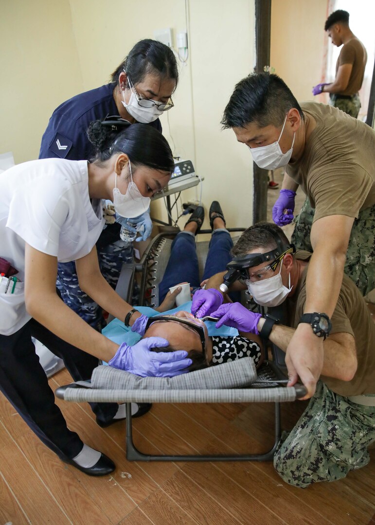 Lt. Cmdr. Ryan Neal performs a tooth extraction on a patient during a Pacific Partnership dental community health engagement in La Union, Philippines.