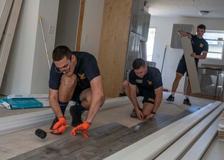 Sailors install flooring at a Habitat for Humanity project during Lincoln Nebraska Navy Week.
