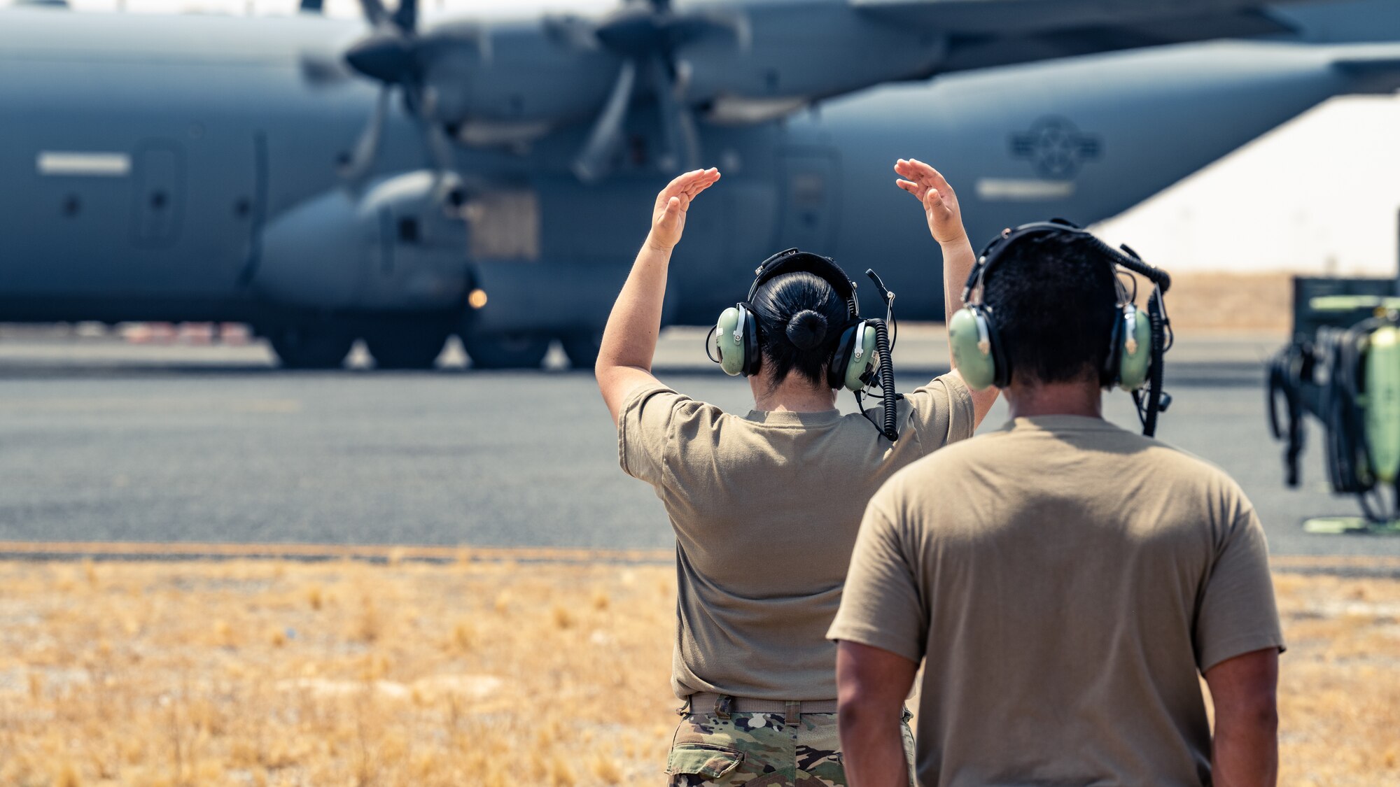 Senior Airman Danaelin Claudio Agosto, 386th Expeditionary Logistics Readiness Squadron AFCENT manager journeyman, martials a C-130J Super Hercules as it prepares to take-off during a training event with the 386th Expeditionary Aircraft Maintenance Squadron at Ali Al Salem Air Base, Kuwait, Aug. 22, 2023. Airmen from both squadrons trained each other and swapped roles for this event to ensure everyone remains multi-capable and ready to lend a hand in generating airpower wherever they are needed. (U.S. Air Force photo by Staff Sgt. Kevin Long)