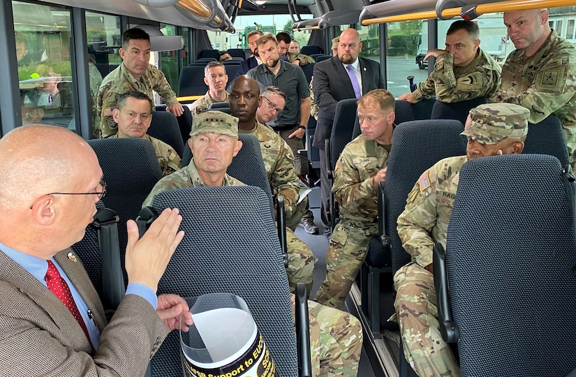 Joseph Scheff, the 405th Army Field Support Brigade deputy to the commander, briefs Vice Chief of Staff of the Army Gen. Randy George, Sgt. Major of the Army Michael Weimer, and other senior officials and leaders while conducting a windshield tour of the Coleman Army Prepositioned Stocks-2 worksite in Mannheim, Germany, Aug. 25. Due to the limited amount of time the VCSA and SMA were on the ground much of the information briefed was done on the move.