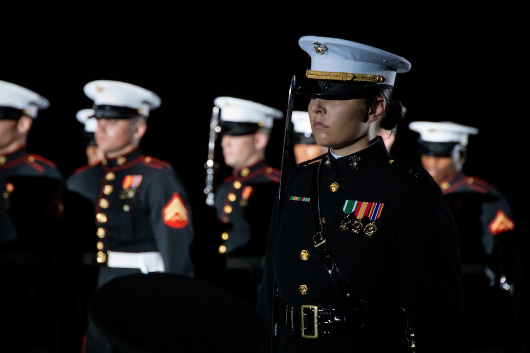 Marines march in a formation at night.