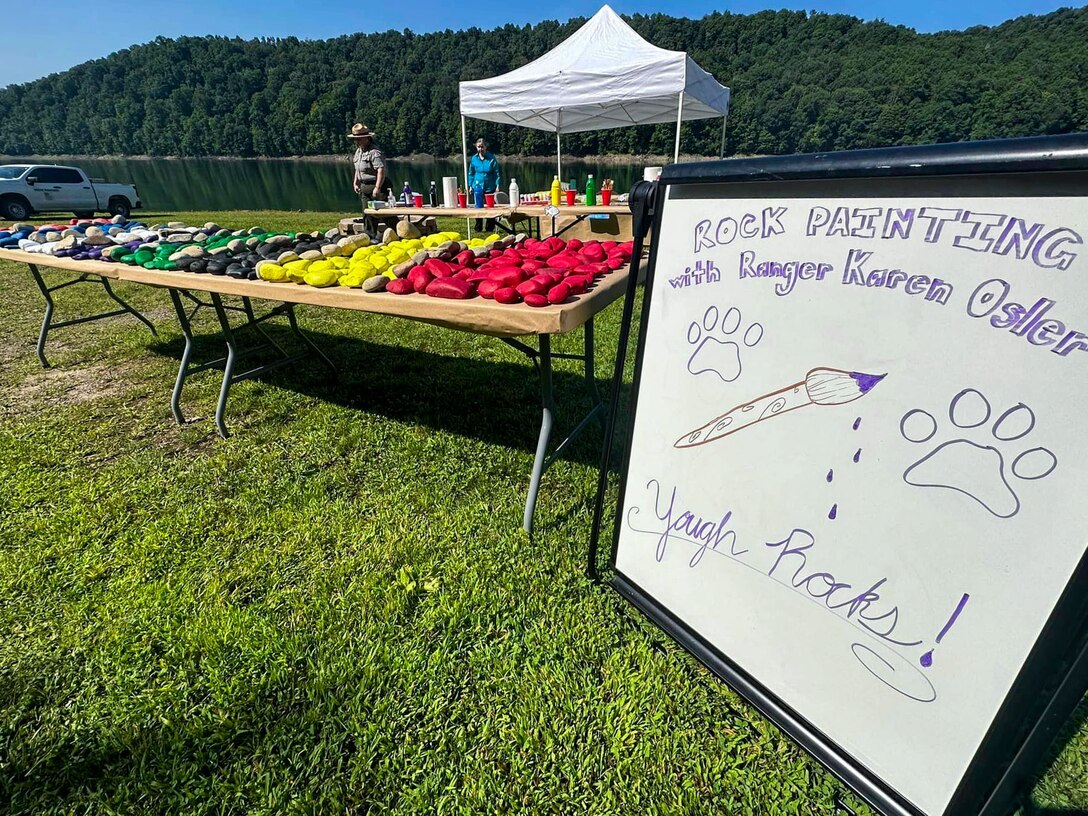 U.S. Army Corps of Engineers Park Ranger Karen Osler hosts a rock-painting booth during the Youghiogheny River Lake’s 75th celebration in Confluence, Pennsylvania on Aug. 19, 2023.