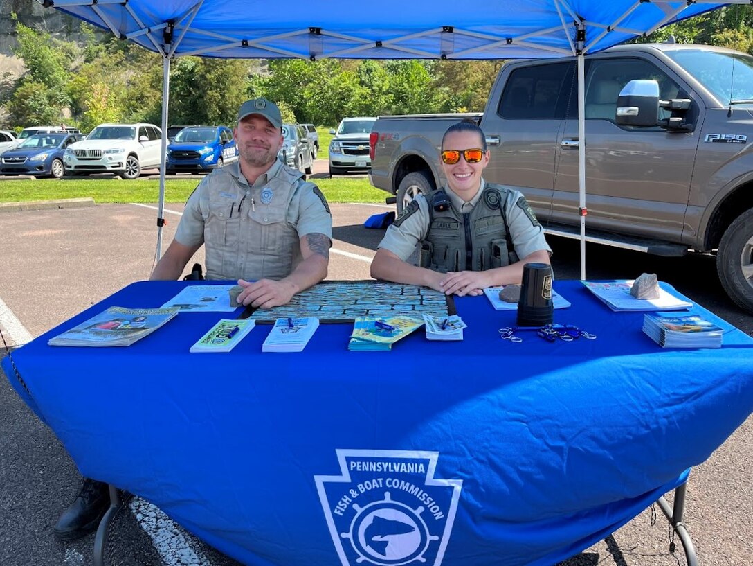 Pennsylvania Fish and Boat Commission waterways conservation officers Tyler Crooks (left) and Dina Cable (right) hosted a booth at Youghiogheny River Lake’s 75th anniversary celebration in Confluence, Pennsylvania on Aug. 19, 2023. The commission is responsible for managing the lake’s fishery and enforcing boating laws around the lake.
