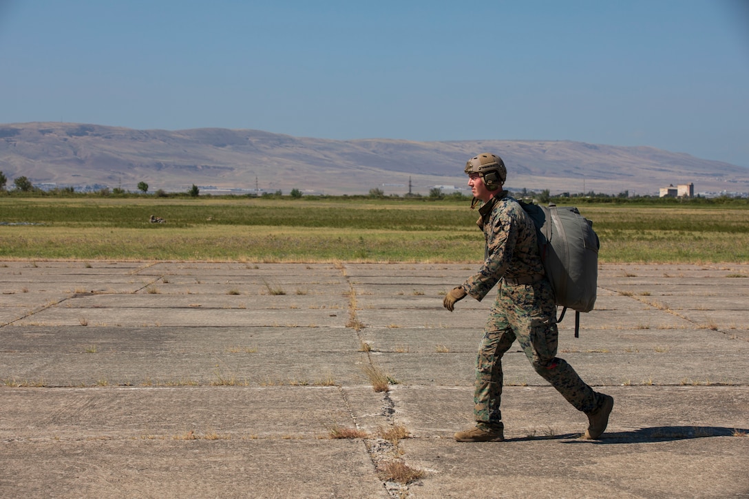 U.S. Marine Corps Cpl. Max Halpin of 2d Landing Support Battalion, United States Marine Corps, recovers his parachute following an airborne jump during exercise Agile Spirit 23 at Vaziani Training Area, Georgia, Aug. 23, 2023. The operation was the first joint Army-Marine Corps jump in Agile Spirit history. (U.S. Army National Guard photo by Sgt. Allison Gilstrap)