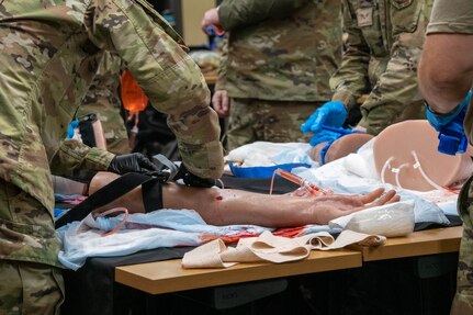 An Airman from the 138th Medical Group applies a combat tourniquet to a bleeding mannequin part during Tactical Combat Casualty Care (TCCC) training in a PACEM Defense classroom at Perry, Fla., July 19, 2023. Some of the techniques learned in the classroom included needle decompression, how to splint, and how to apply a combat tourniquet in order to be ready for anything when out in the field. (Oklahoma National Guard Photo by Airman 1st Class Addison Barnes)