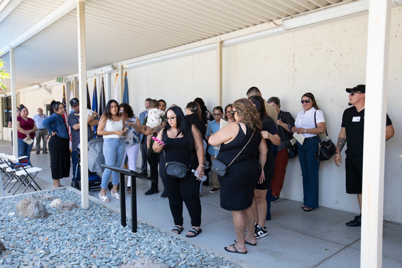 Family members of DLA Distribution San Joaquin, California, employees who lost their lives to the COVID pandemic take photos of a monument dedicated to their loved ones during an event on Aug. 18, 2023, at the DDJC installation. DLA photo by Julian Temblador.
