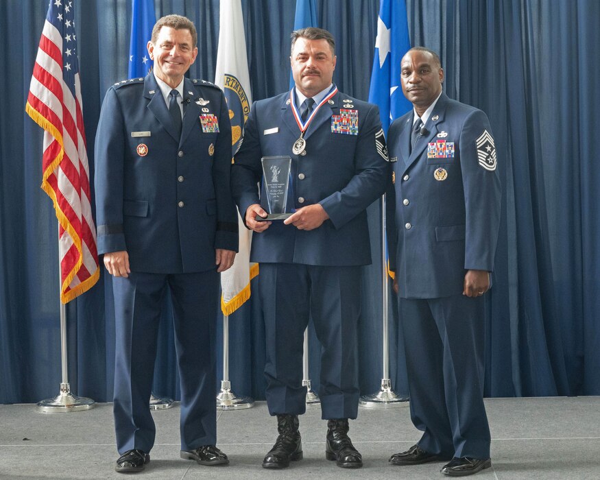 U.S. Air Force Senior Master Sgt. Tony Hall, center, Tactical Air Control Party, 118th Air Support Operations Squadron, 145th Airlift Wing, North Carolina National Guard poses with Lt. Gen. Michael Loh, left, director, Air National Guard and Chief Master Sgt. Maurice Williams, command chief, ANG after being recognized as the ANG’s Outstanding Senior Non Commissioned Officer of the Year at the Air National Guard Readiness Center, Joint Base Andrews, Maryland, Aug. 24, 2023.