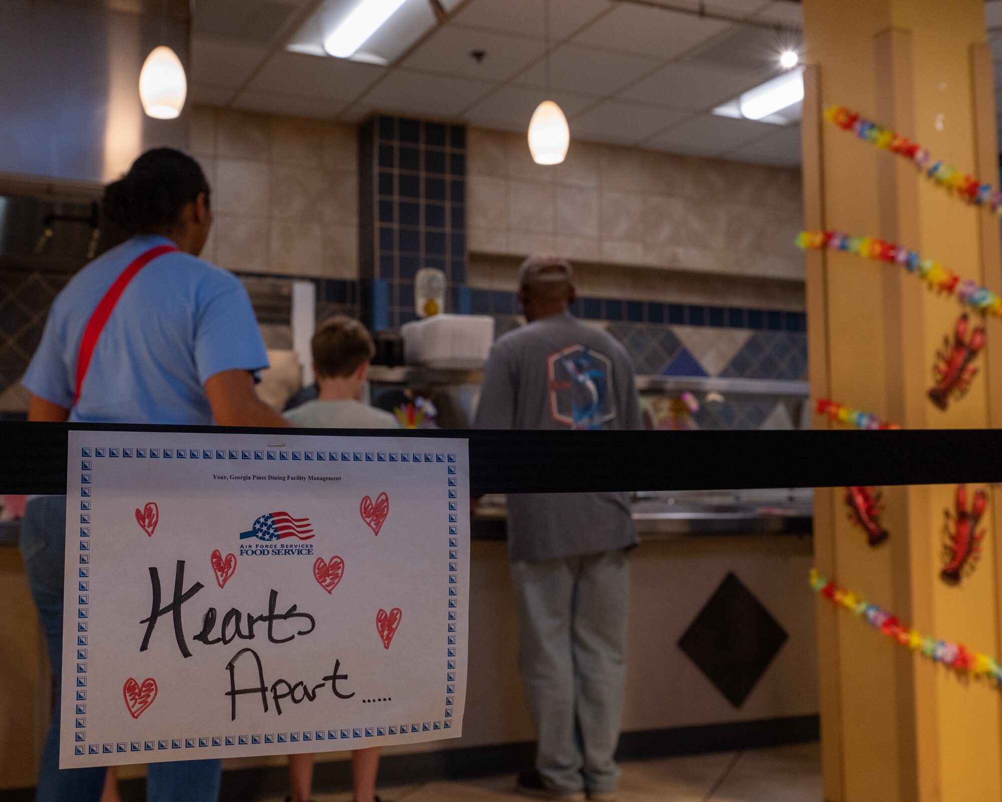 Volunteers stand in line to pick up food for the Hearts Apart dinner at Moody Air Force Base, Georgia, Aug. 17, 2023. Events like these allow attendees to build friendships and help ease the stress and demands on families during deployment. (U.S. Air Force photo by Airman 1st Class Leonid Soubbotine)