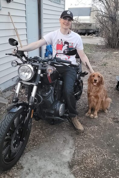 Senior Airman Caleb S. Kimmell, 5th Bomb Wing Public Affairs photojournalist, poses for a photo with his dog Cleo in Minot, North Dakota, May 20, 2023. Kimmell purchased the motorcycle and learned how to ride safely over the course of the summer.