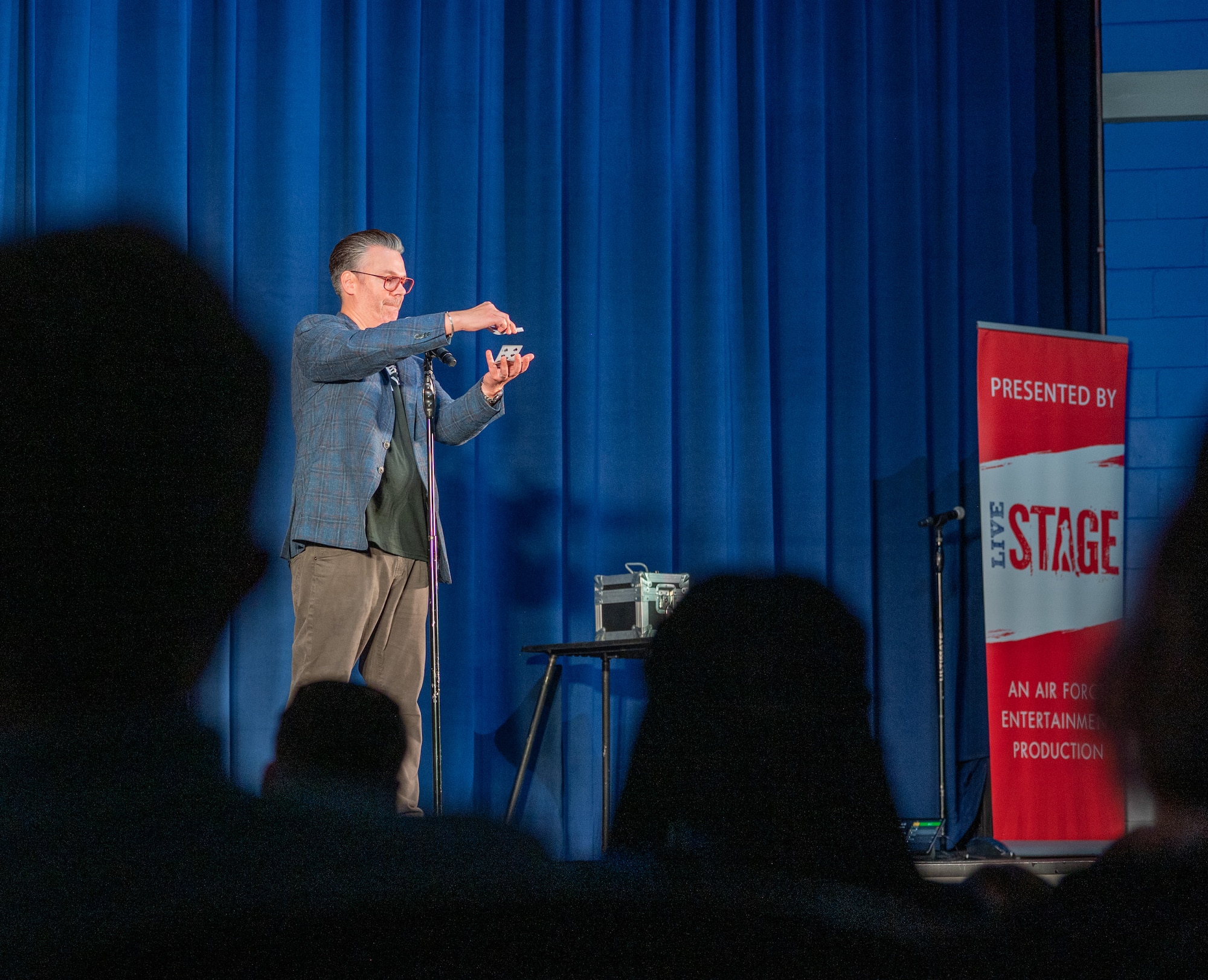Derek Hughes, a comedian, performs a card trick during the Smash Up Comedy night at Moody Air Force Base, Georgia, Aug. 17, 2023. The Smash Up Comedy tour was an on-base family event which dazzled the audience with comedy, magic, and music. (U.S. Air Force photo by Airman 1st Class Leonid Soubbotine)