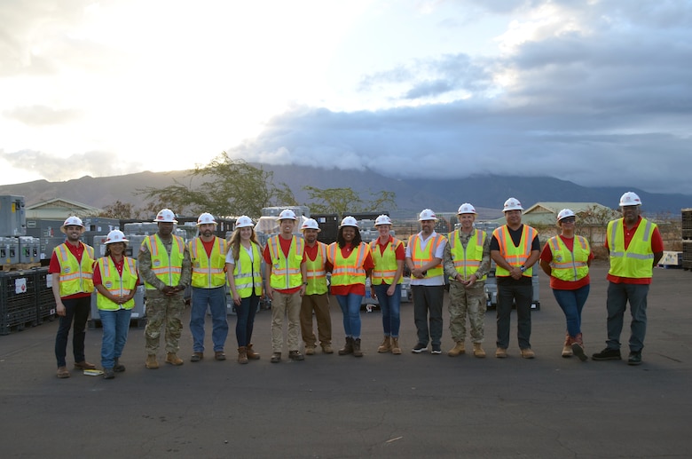 A large group of people in safety vests and hardhats pose for a group photo