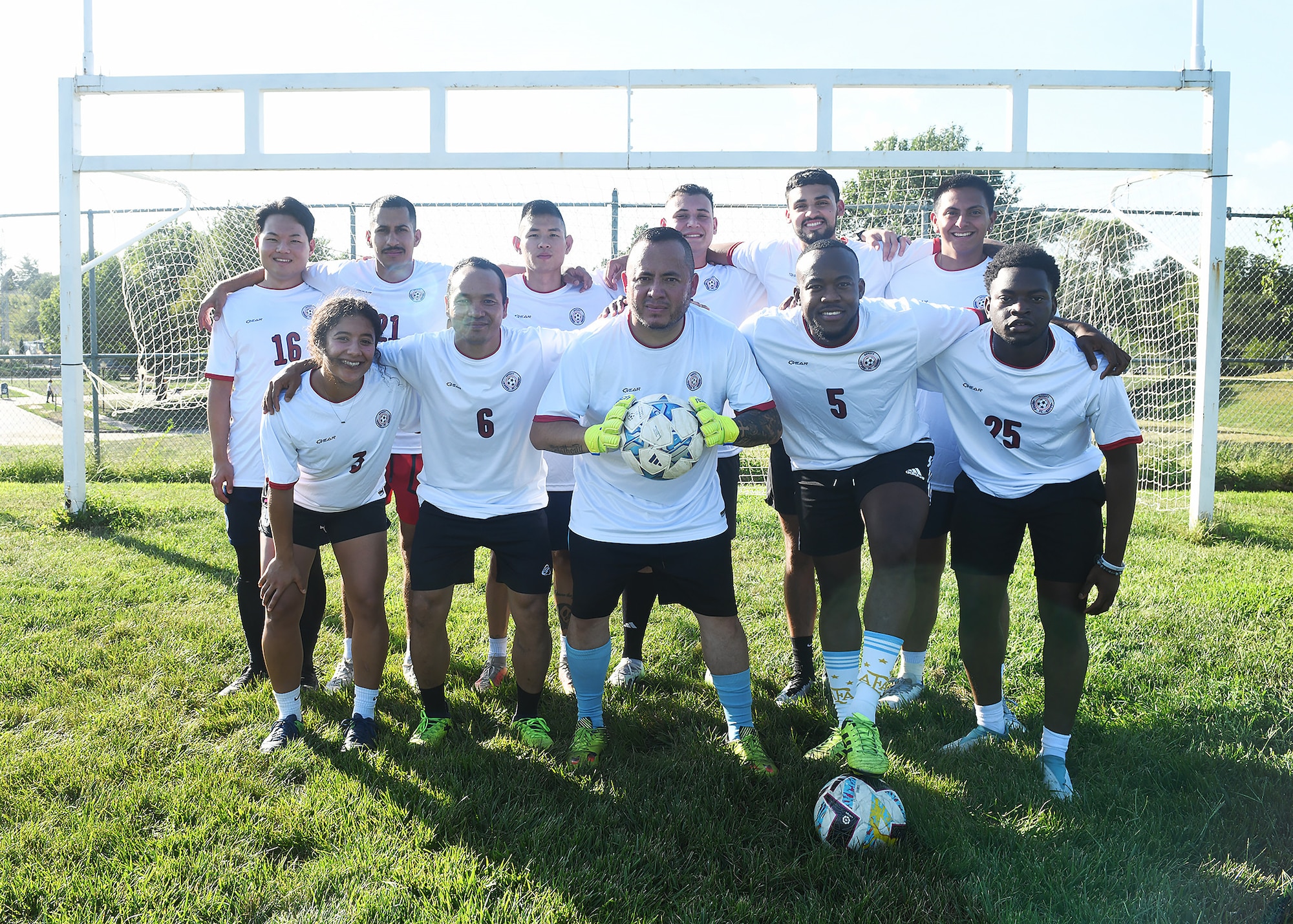 Soccer players taking a photo in front of a goal