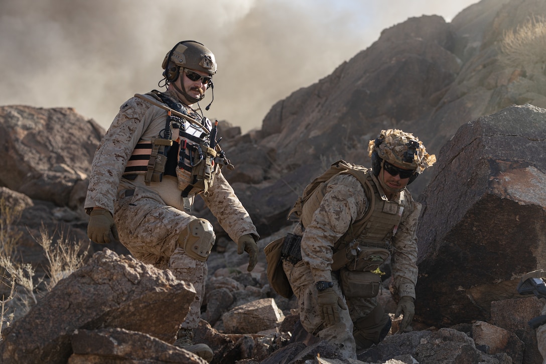 A U.S. Navy Corpsman and U.S. Marine Corps Lance Cpl. Joseph Gates II, 2nd Battalion, 2nd Marine Regiment, 2nd Marine Division, take cover from a controlled detonation during Integrated Training Exercise (ITX) 3-23 at Marine Corps Air Ground Combat Center, Twentynine Palms, California, April 15, 2023. The purpose of ITX is to create a challenging, realistic, training environment that produces combat-ready forces capable of operating as an integrated Marine Air-Ground Task Force (MAGTF) and to prepare units for their role in the MAGTF Warfighting Exercise. (U.S. Marine Corps photo by Lance Cpl. Richard PerezGarcia)