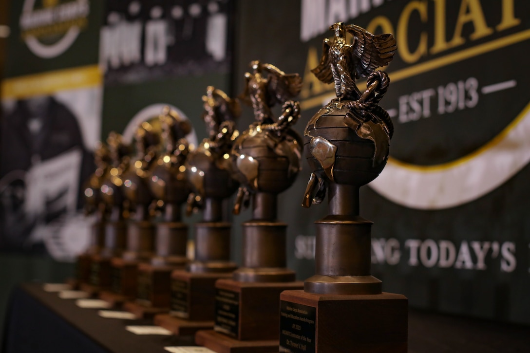 Awards rest on a stage before an awards ceremony in Arlington, Virginia, Aug. 10, 2023. The purpose of the ceremony was to congratulate and recognize distinguished instructors. (U.S. Marine Corps photo by Cpl. Tanner Pittard)