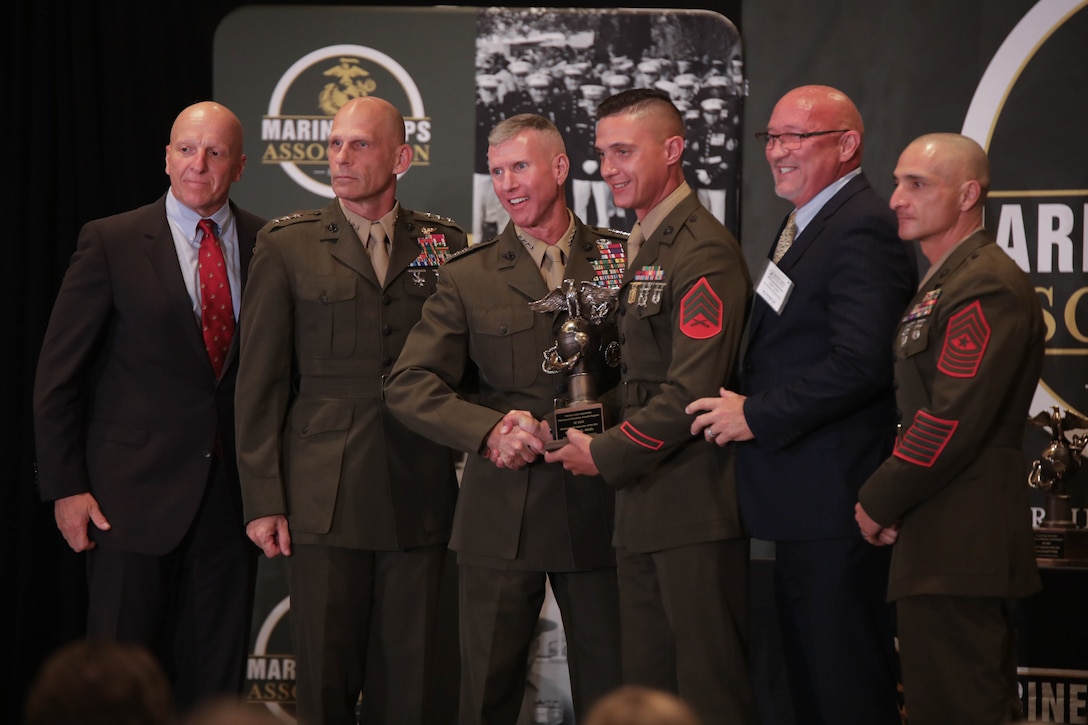 U.S. Marine Corps Gen. Eric M. Smith, 36th Assistant Commandant of the Marines Corps, presents an award to Sgt. Samuel L. Mullis, a marksmanship instructor, during an awards ceremony in Arlington, Virginia, Aug. 10, 2023. Mullis, a native of Monroe, North Carolina, was recognized by the Marine Corps as the Marksmanship Coach/Instructor of the Year for 2022. (U.S. Marine Corps photo by Cpl. Tanner Pittard)