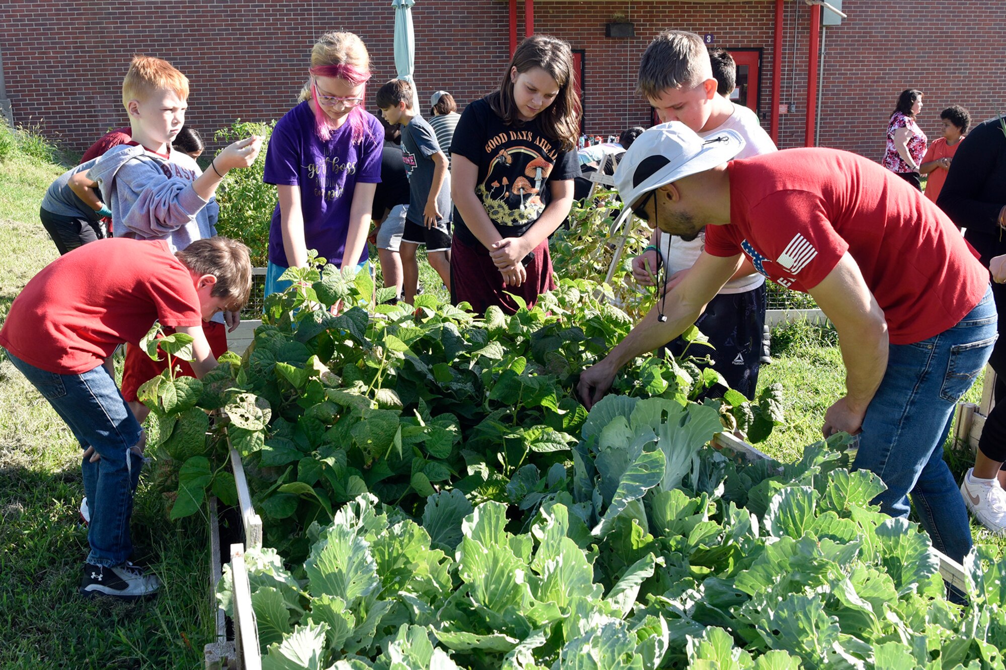 Adults and kids work in a garden