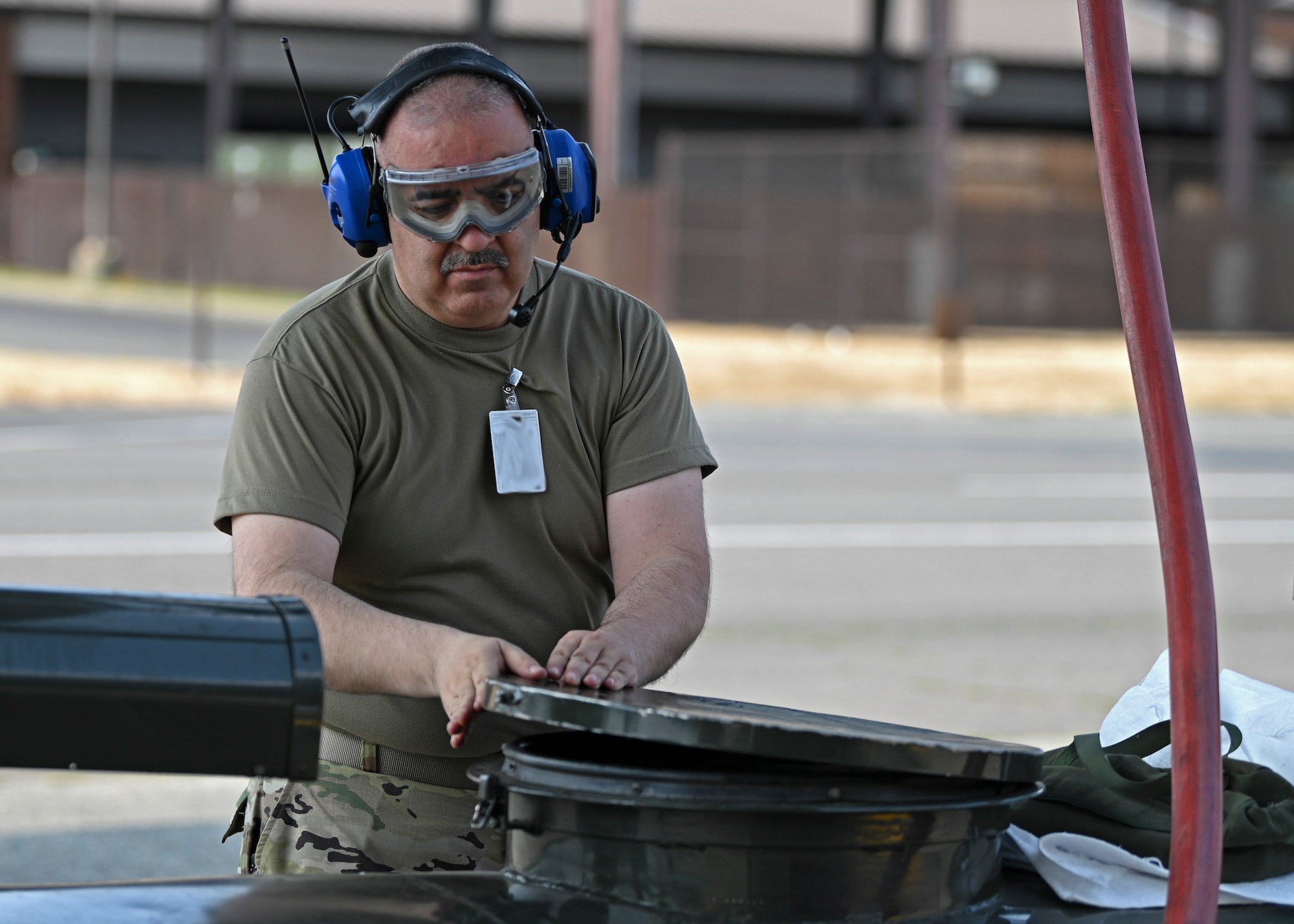U.S. Air Force Tech. Sgt. Louis Trujillo, aircraft fuel systems technician with the 446th Maintenance Squadron, closes a fuel bowser at Joint Base Lewis-McChord, Washington, Aug. 23, 2023. Fuel bowsers are used to conduct jettison butterfly valve operational checkouts, where fuel is offloaded from a C-17 Globemaster III to ensure safe landings and takeoffs. (U.S. Air Force photo by Senior Airman Callie Norton) (Badges blurred for security purposes)
