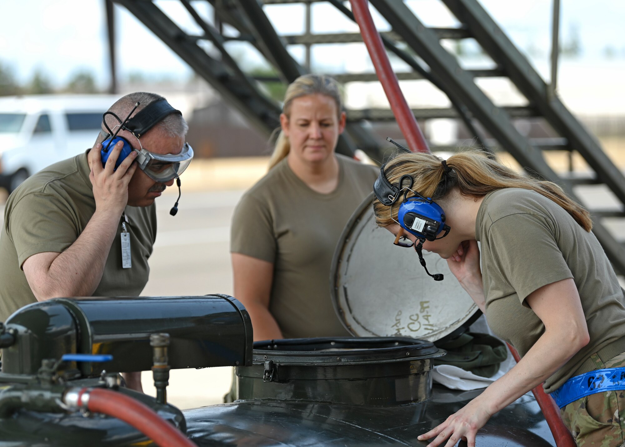 U.S. Air Force Tech. Sgt. Louis Trujillo, left, aircraft fuel systems technician with the 446th Maintenance Squadron and Senior Airman Britteny Cox, right, aircraft fuel systems technician with the 62d Maintenance Squadron, check for fuel in a fuel bowser at Joint Base Lewis-McChord, Washington, Aug. 23, 2023. Fuel bowsers are used to conduct jettison butterfly valve operational checkout, where fuel is offloaded from a C-17 Globemaster III to ensure safe landings and takeoffs. (U.S. Air Force photo by Senior Airman Callie Norton) (Badges blurred for security purposes)