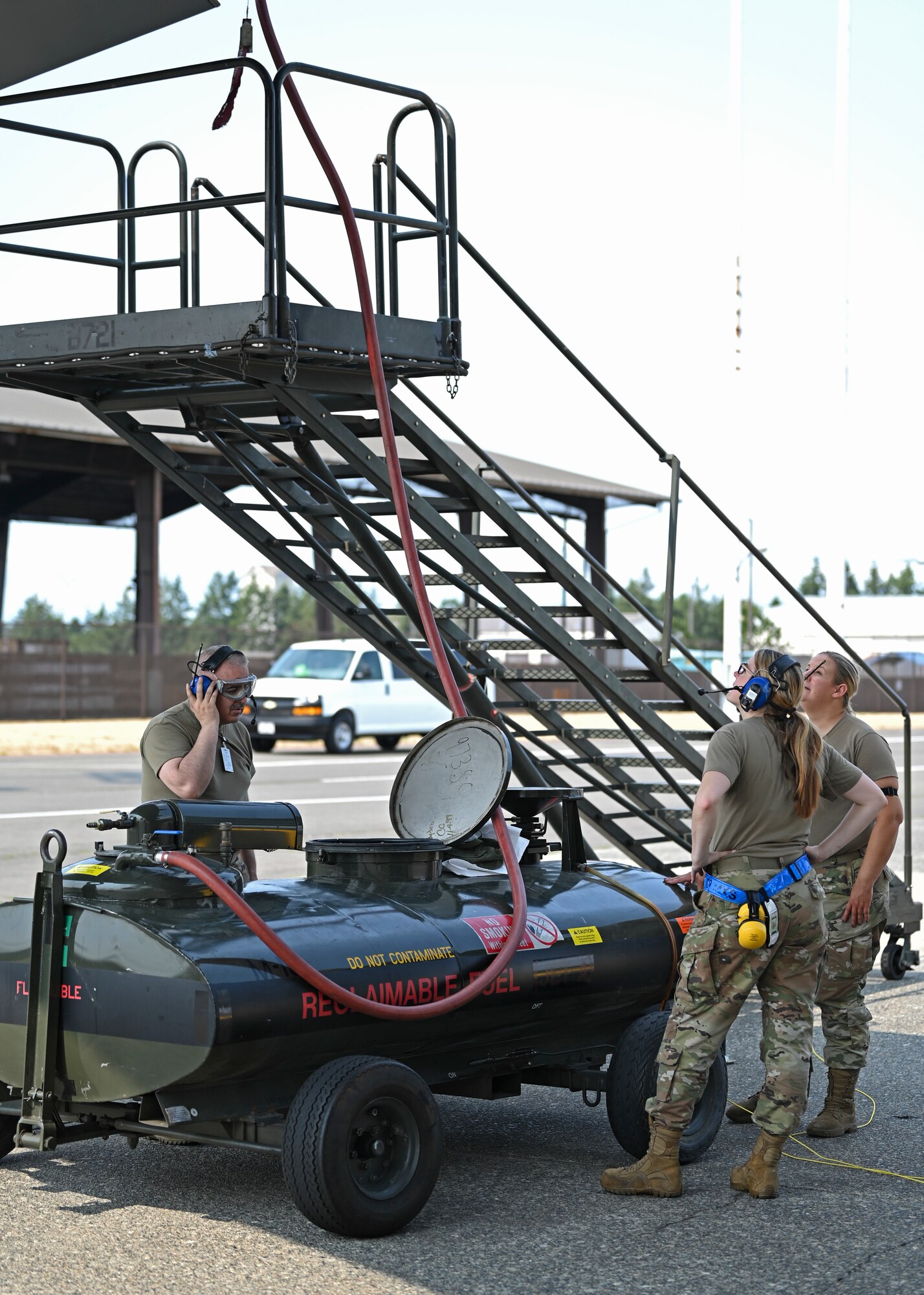 U.S. Air Force Tech. Sgt. Louis Trujillo, left, aircraft fuel systems technician with the 446th Maintenance Squadron, and Senior Airman Britteny Cox, center, aircraft fuel systems technician with the 62d Maintenance Squadron, and Master Sgt. Carla Inch, aircraft fuel systems section chief with the 446th MXS, conduct a jettison butterfly valve operational checkout at Joint Base Lewis-McChord, Washington, Aug. 23, 2023. This operational checkout ensures fuel dumps are working properly so a C-17 Globemaster III can offload fuel quickly if needed. (U.S. Air Force photo by Senior Airman Callie Norton) (Badges blurred for security purposes)