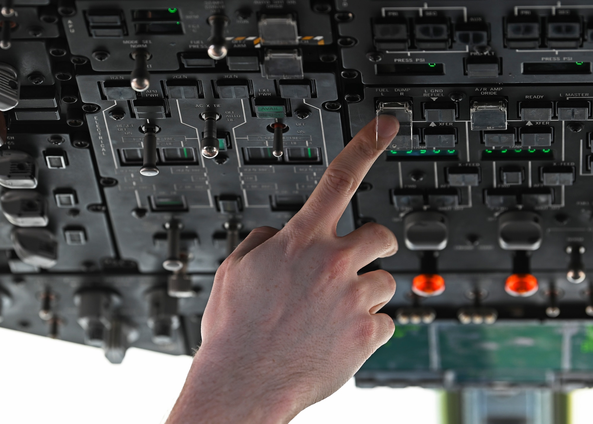 U.S. Air Force Staff Sgt. Isaac Ashton, aircraft fuel systems technician with the 62d Maintenance Squadron, points to the fuel dump switch on the engine start panel of a C-17 Globemaster III at Joint Base Lewis-McChord, Washington, Aug. 23, 2023. This switch is used to offload fuel quickly to ensure safe takeoffs and landings. (U.S. Air Force photo by Senior Airman Callie Norton)