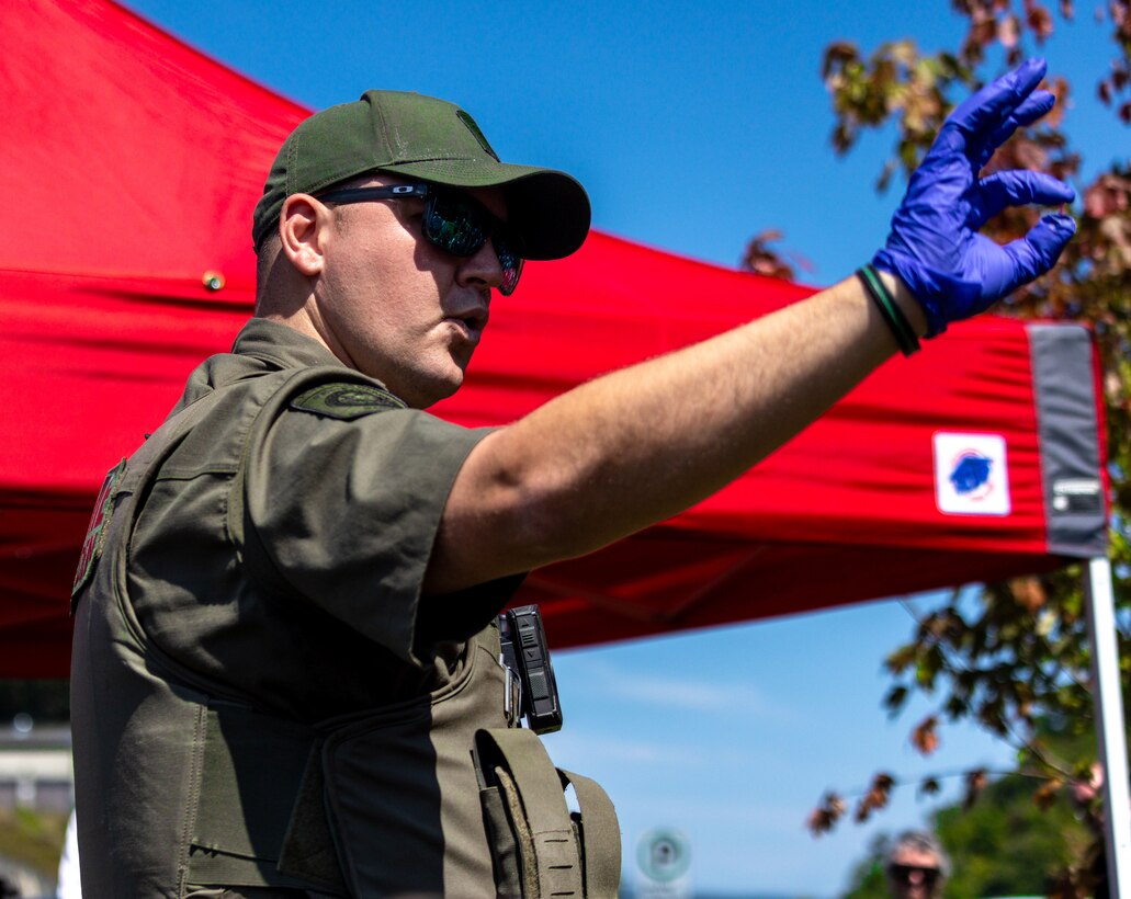 Pennsylvania Game Commission Officer Andrew Harvey displays a tooth taken from a captured black bear during Youghiogheny River Lake’s 75th celebration in Confluence, Pennsylvania on Aug. 19, 2023. The commission brought a sedated black bear to the celebration to demonstrate the data collection process for catching, tagging, and relocating black bears caught within the community. A tooth is removed from black bears captured by the commission to determine the bear’s age.