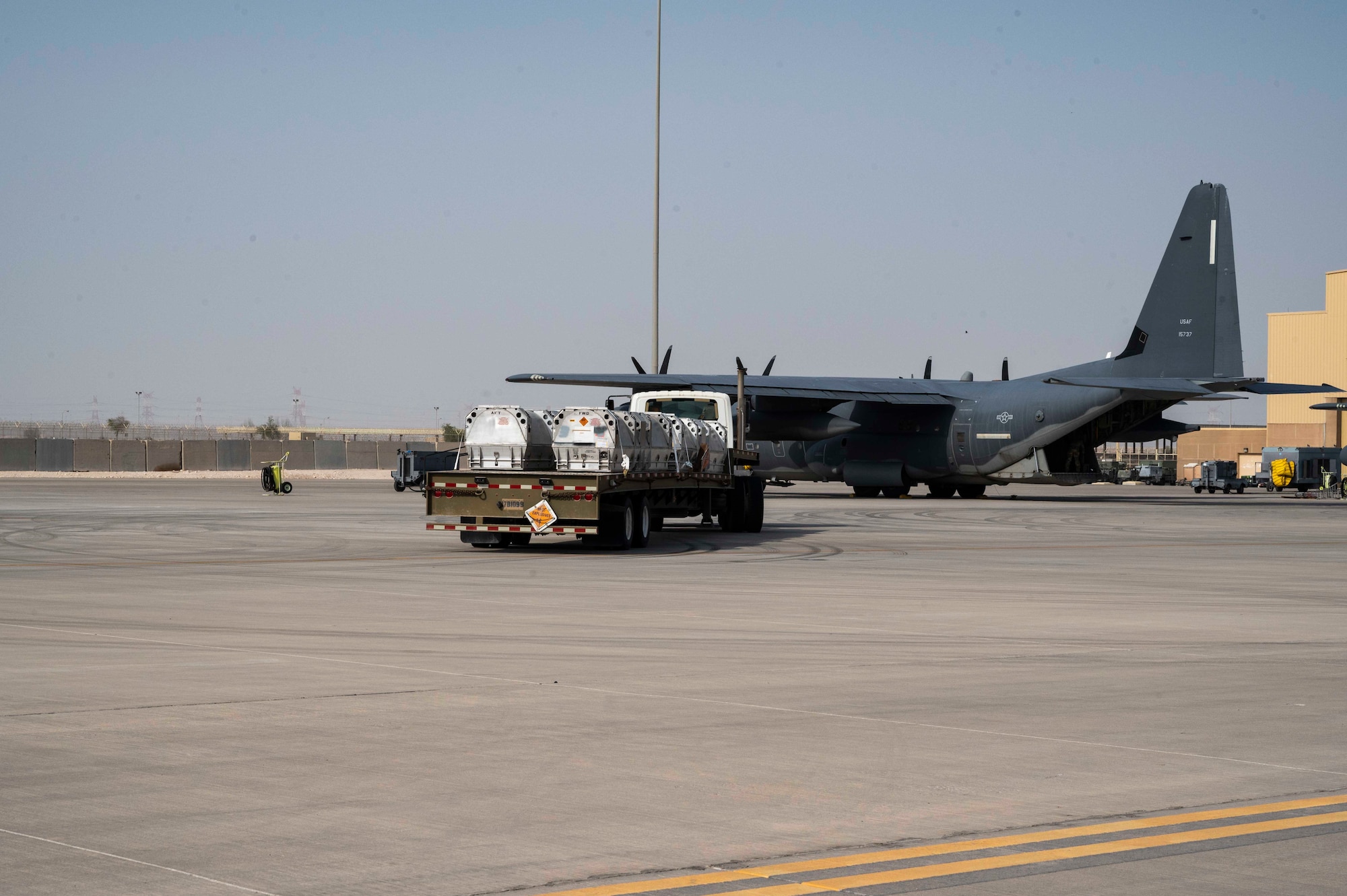 Members of the U.S. Air Force 6th Expeditionary Maintenance Squadron and the 6th Special Operations Tasking Unit stage Joint Air-to-Surface Standoff Missiles (JASSM) next to an MC-130J Commando II at Al Udeid Air Base, Qatar, Aug. 6, 2023. The Rapid Dragon palletized munitions system is capable of deploying long-range cruise missiles using standard airdrop procedures from cargo aircraft like the MC-130J operated by Air Force Special Operations Command. Rapid Dragon is a precision munitions capability for medium-sized or larger cargo aircraft that allows U.S. forces a flexible rapid response option. (U.S. Air Force photo by Staff Sgt. Frank Rohrig)