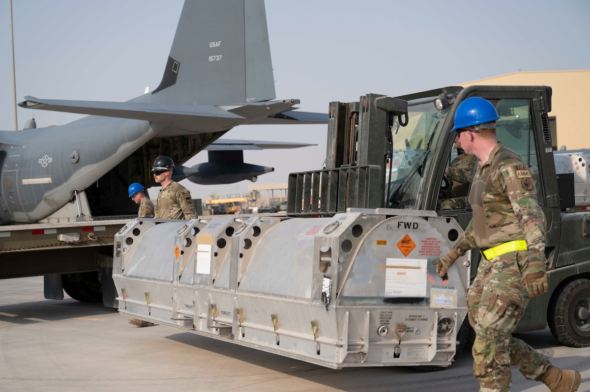 Members of the U.S. Air Force 6th Expeditionary Maintenance Squadron and the 6th Special Operations Tasking Unit stage Joint Air-to-Surface Standoff Missiles (JASSM) next to an MC-130J Commando II at Al Udeid Air Base, Qatar, Aug. 6, 2023. The Rapid Dragon palletized munitions system is capable of deploying long-range cruise missiles using standard airdrop procedures from cargo aircraft like the MC-130J operated by Air Force Special Operations Command. Rapid Dragon is a precision munitions capability for medium-sized or larger cargo aircraft that allows U.S. forces a flexible rapid response option. (U.S. Air Force photo by Staff Sgt. Frank Rohrig)