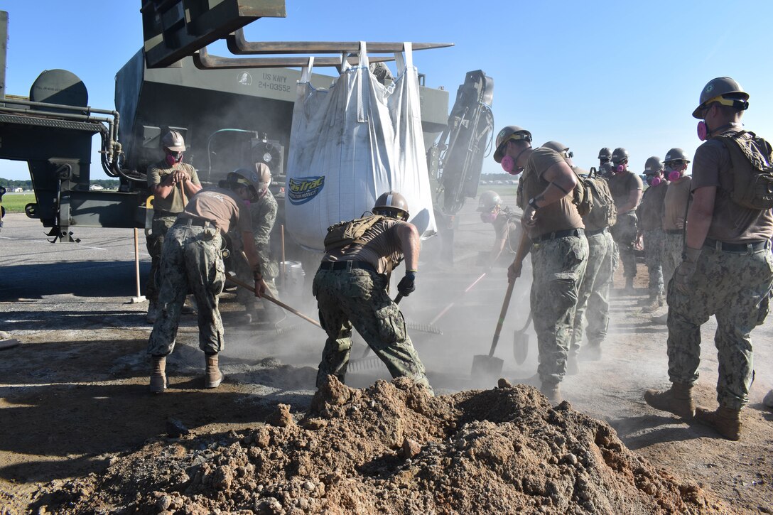 U.S. Navy Seabees assigned to Naval Mobile Construction Battalion 11 spread concrete to fill a hole on an airfield ramp during Large Scale Exercise (LSE) 2023 at Seymour Johnson Air Force Base, North Carolina, Aug. 11, 2023.