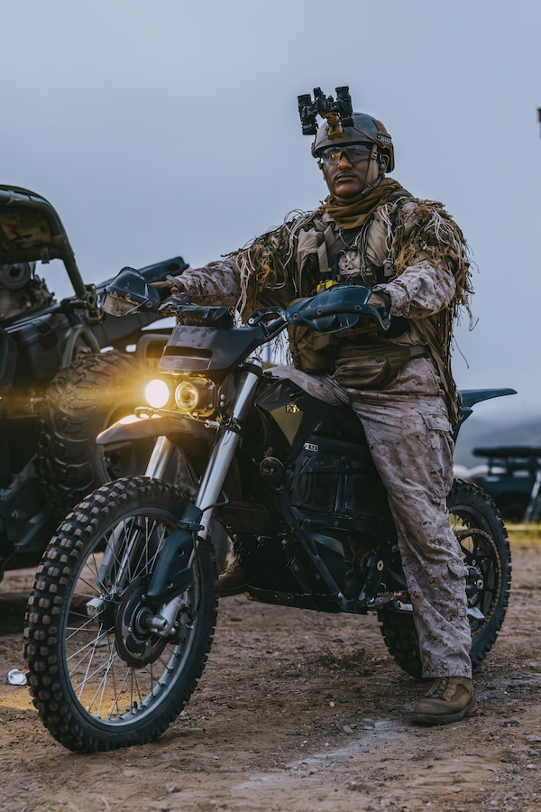 A U.S. Marine assigned to Reconnaissance Company, 15th Marine Expeditionary Unit, starts his MMX motorcycle in preparation for a raid during the ground interoperability exercise at Marine Corps Base Camp Pendleton, California, July 24, 2023. The ground interoperability training integrates Reconnaissance Company and supporting elements into a raid force to conduct land-based, specialized limited-scale raids in preparation for more complex amphibious and maritime operations. (U.S. Marine Corps photo by Cpl. Helms)