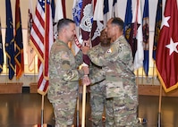 Maj. Gen. Robert L. Edmonson, right, commanding general of U.S. Army Communications-Electronics Command, passes the Army Medical Logistics Command’s unit colors to AMLC’s new commander, Col. Marc R. Welde, during an assumption of command ceremony Aug. 24 at Fort Detrick, Maryland. Also pictured is AMLC Sgt. Maj. Akram Shaheed.