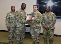 Col. Gary Cooper, center left, outgoing commander of Army Medical Logistics Command, presents the 2022 Army Exceptional Organization Safety Award for the battalion level to Lt. Col. Mark Sander, commander of the U.S. Army Medical Materiel Center-Korea, and Master Sgt. Willie Green, USAMMC-K senior enlisted leader. Alongside Cooper is AMLC Sgt. Maj. Akram Shaheed. It’s the first time USAMMC-K has earned the Army-wide safety honor.