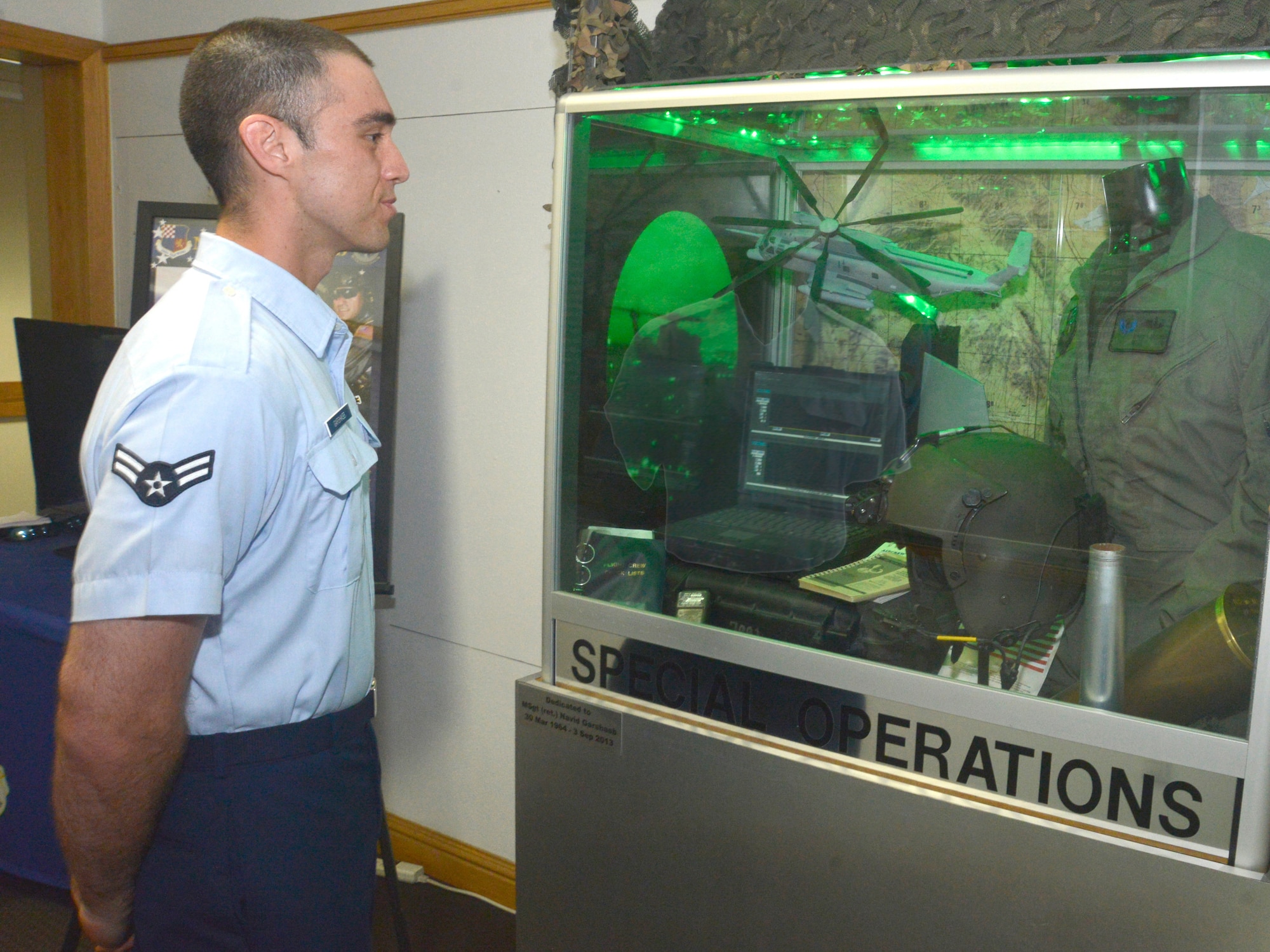 A photo of an Airmen looking into a display case. 