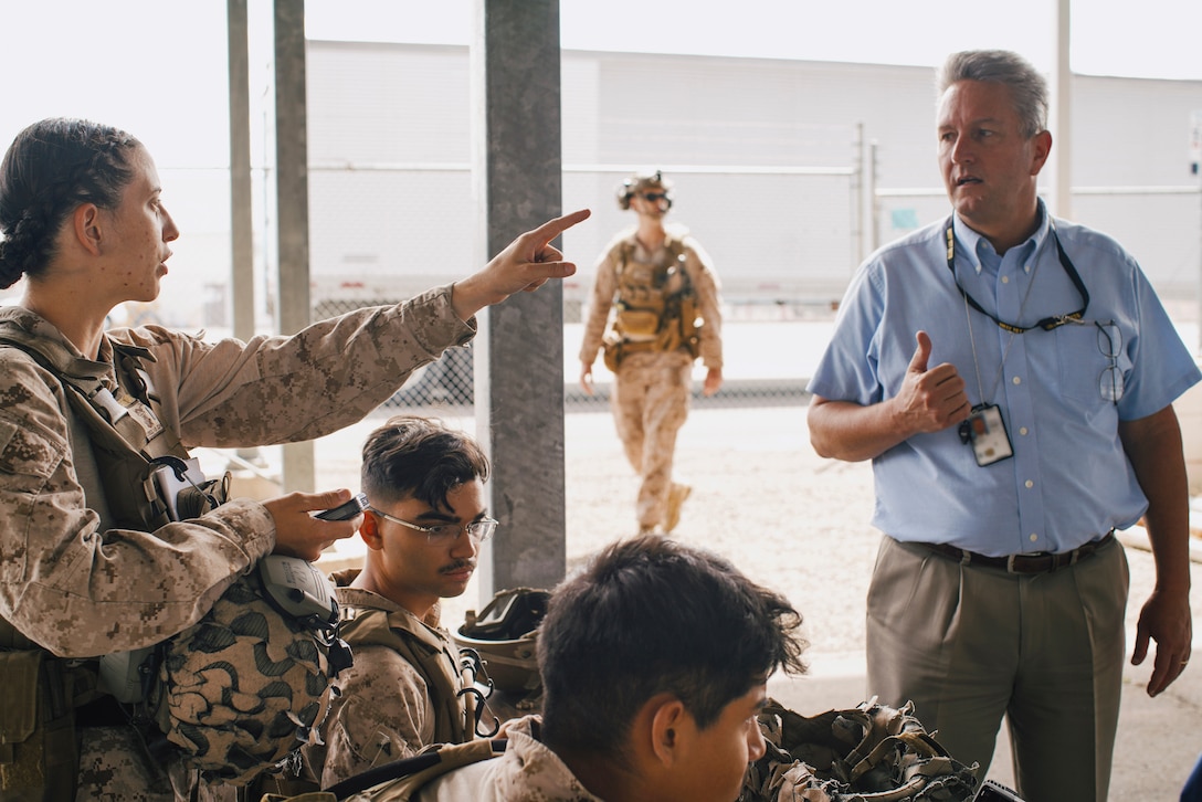 U.S. Marine Corps 1st Lt. Kaylee Mackenzie, left, a combat engineer officer assigned to Combat Logistics Battalion 15, 15th Marine Expeditionary Unit, explains processing procedures for evacuees during a simulated military assisted departure as part of Realistic Urban Training exercise in Reno, Nevada, Aug. 24, 2023. During the scenario, the 15th MEU conducted a mission coordinating with a U.S. Consulate until the situation necessitated an evacuation of consulate staff and American citizens from the area. RUT is a land-based predeployment exercise which enhances the integration and collective capability of the Marine Air-Ground Task Force while providing the 15th MEU an opportunity to train and execute operations in an urban environment. (U.S. Marine Corps photo illustration by 1st Lt. Robert Nanna) (This photo has been altered for security purposes by blurring out an identification badge.)