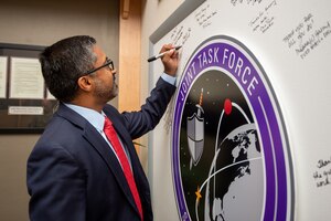 Man in suit signs white board