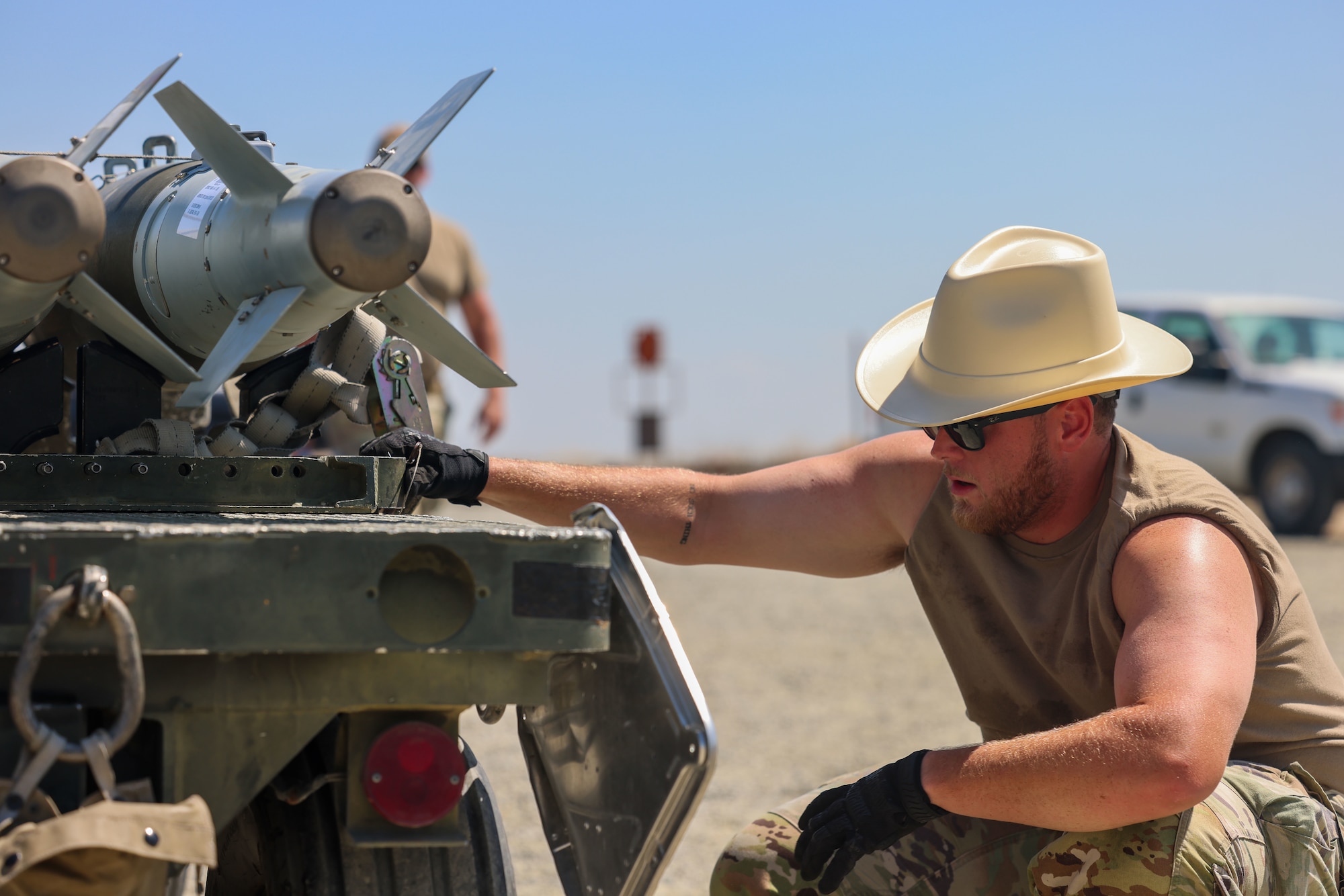 U.S. Air Force Staff Sgt. Chase Senter, 56th Equipment Maintenance Squadron line delivery crew chief, from Luke Air Force Base, Arizona, inspects a trailer carrying bombs during the Air Force Combat Operations Competition (AFCOCOMP) on Beale AFB, California, Aug. 24, 2023.