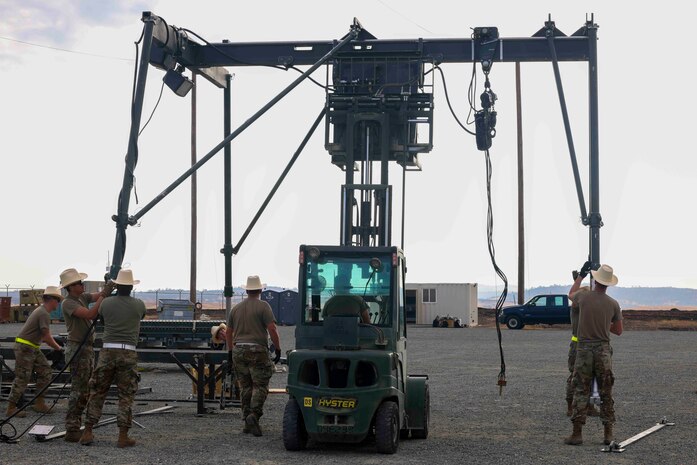 U.S. Air Force Airmen from Luke Air Force Base, Arizona, 56th Equipment Maintenance Squadron munitions flight, build a munitions assembly conveyer while competing in the Air Force Combat Operations Competition, Aug. 22, 2023, at Beale AFB, California.
