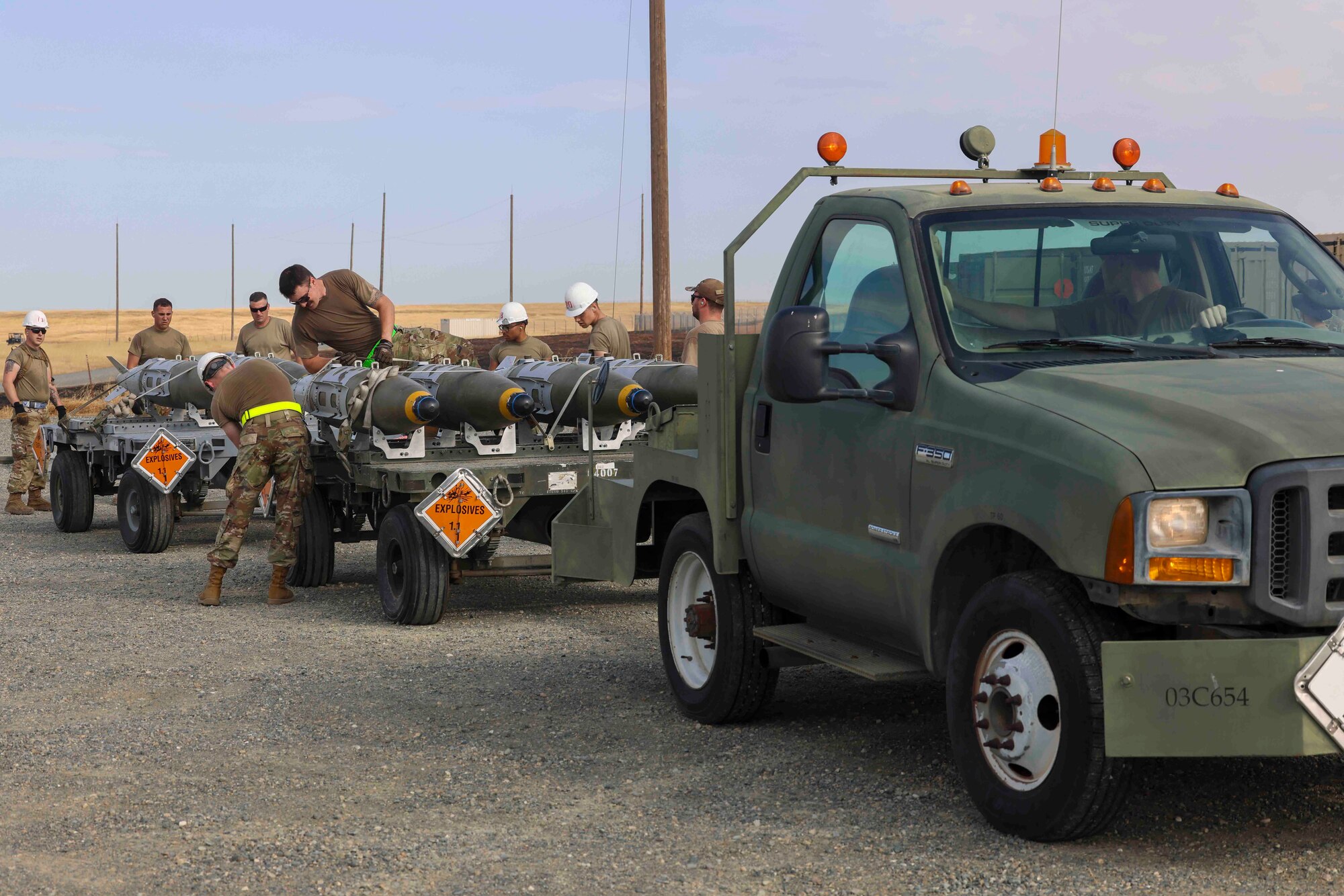 U.S. Air Force Airmen from Whiteman Air Force Base, Missouri, 509th Munitions Squadron, conduct a trailer build of GBU-32 munitions while competing in the Air Force Combat Operations Competition, Aug. 22, 2023, at Beale AFB, California.