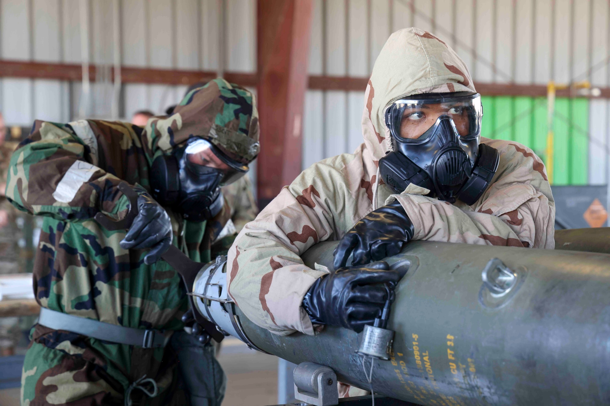 U.S. Air Force Airmen from Whiteman Air Force Base, Missouri, 509th Munitions Squadron, build GBU-54 munitions in MOPP gear to simulate building munitions even in the event of a CBRN attack during the Air Force Combat Operations Competition, Aug. 23, 2023, at Beale AFB, California.