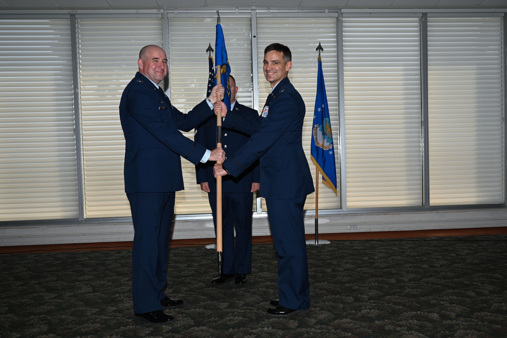U.S. Air Force Col. Robert Cocke, 350th Spectrum Warfare Group commander, left, passes the guidon to U.S. Air Force Lt. Col. Luke Marron, 350th Spectrum Warfare Group, Detachment 1 assuming commander, right, at Eglin Air Force Base, Aug. 25, 2023. The 350th SWG, Det 1 will enhance the Combat Air Force’s survivability in the electromagnetic spectrum while accomplishing function and theater-specific Combatant Commander assigned missions. (U.S. Air Force photo by Staff Sgt. Ericka A. Woolever)