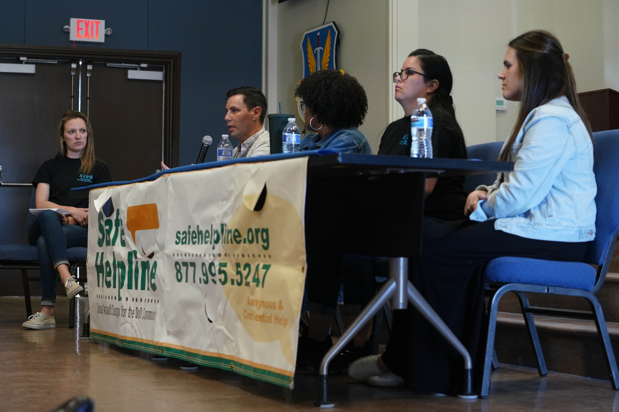 A panel sitting and speaking during a Denim Day Panel.