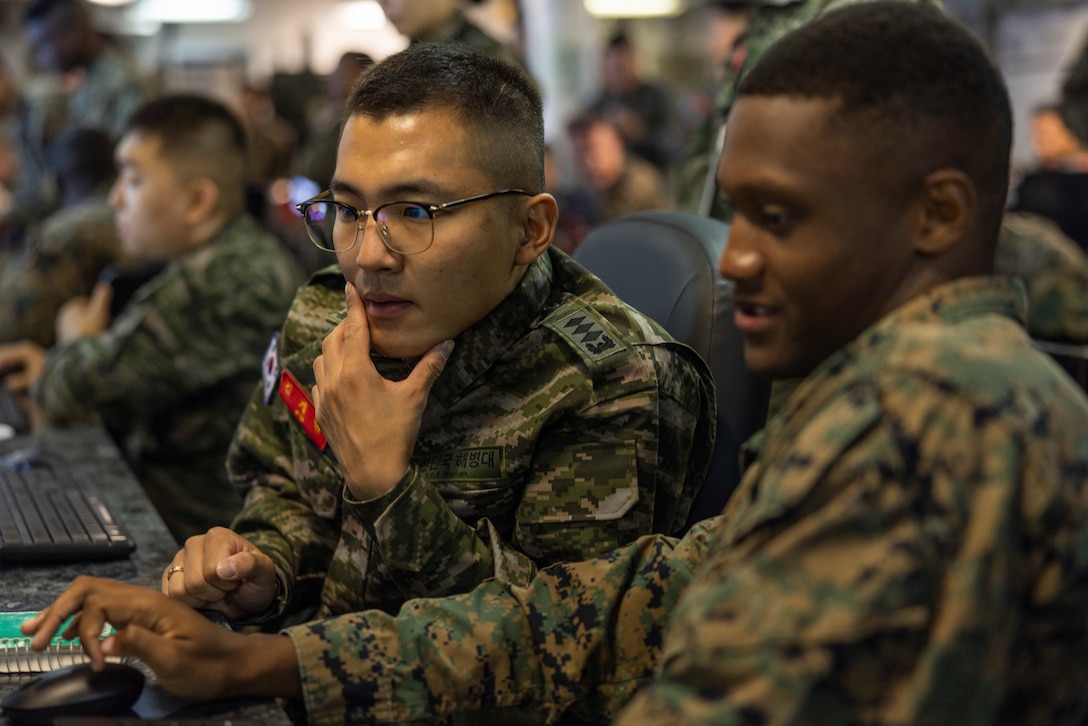 Republic of Korea Marine Corps Capt. Jae Hyun Kim, a public affairs officer with 1st Marine Division, left, and U.S. Marine Corps 2nd Lt. Keyon Whyte, a communication strategy and operations officer with III Marine Expeditionary Force work together in the Landing Force Operations Center aboard the USS Blue Ridge (LCC-19) in support of Ulchi Freedom Shield 23, August 25, 2023. U.S. 7th Fleet’s flagship USS Blue Ridge is in port at Fleet Activities Yokosuka in Yokosuka, Japan. Ulchi Freedom Shield is a defense-oriented exercise designed to strengthen the ROK-U.S. Alliance, enhance our combined defense posture, and strengthen security and stability on the Korean peninsula. Whyte is a native of Atlanta, Georgia. (U.S. Marine Corps photo by Cpl. Tyler Andrews)