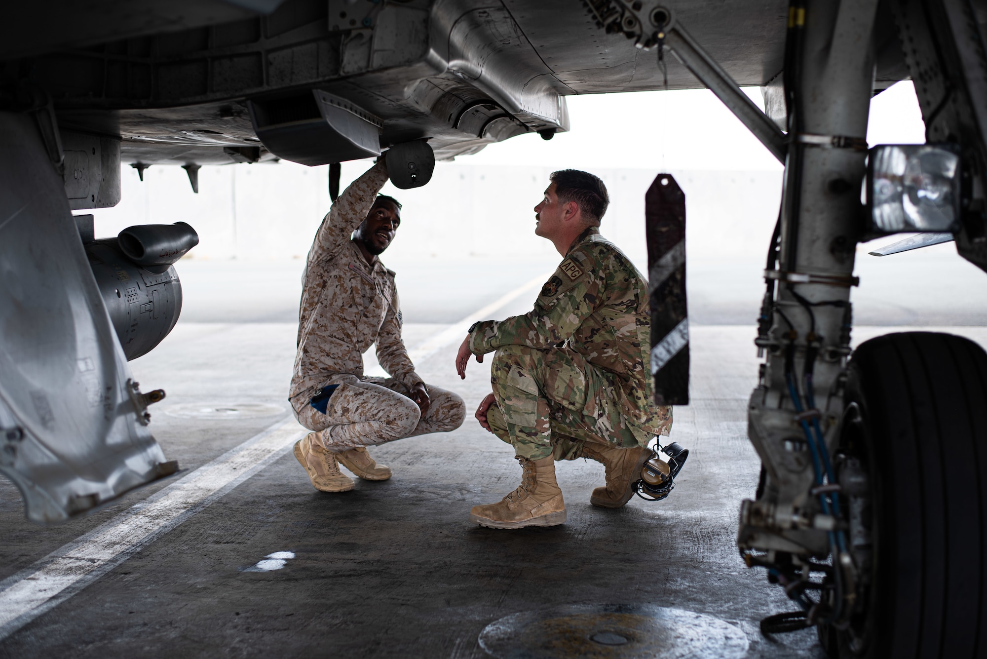 U.S. Air Force Staff Sgt. Jonathan Miles (right), 125th Expeditionary Fighter Generation Squadron (EFGS) crew chief, inspects a maintenance hatch on a Eurofighter Typhoon with a maintainer from the Royal Saudi Air Force (RSAF) during Operation Agile Spartan, Kingdom of Saudi Arabia, Aug. 21, 2023. During the exercise, RSAF and 125th EFGS maintainers toured each other's aircraft to see how each partner nation performs their maintenance duties. Agile Spartan 23.2 is a multinational operation aimed at strengthening interoperability, improving response capabilities, and furthering security cooperation initiatives throughout the U.S. Central Command area of responsibility. (U.S. Air Force photo by Tech. Sgt. Alexander Frank)
