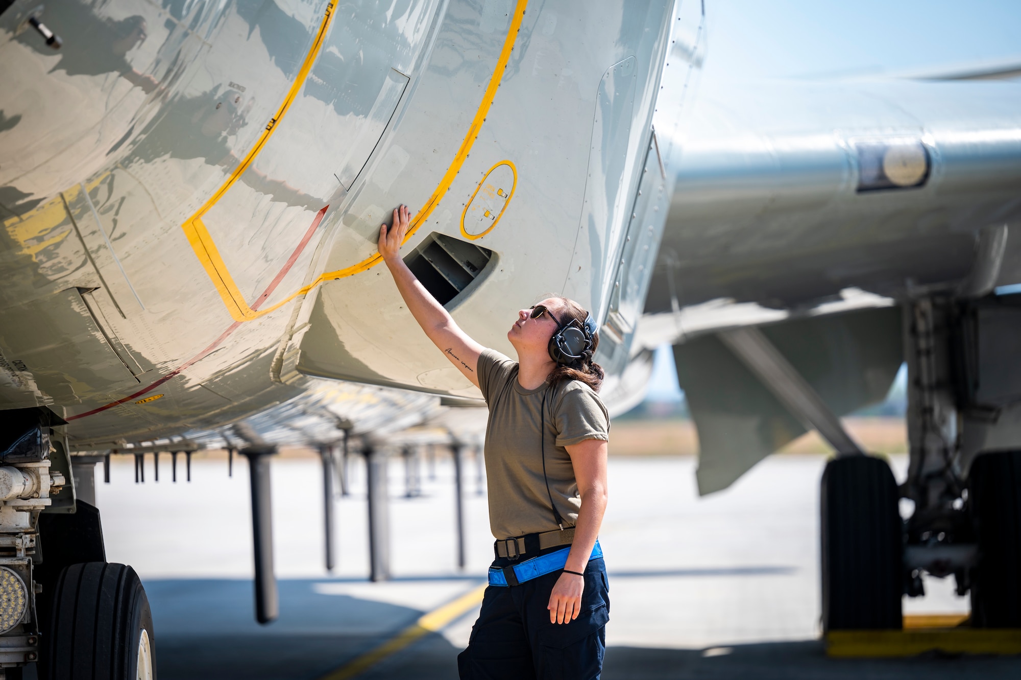 Service member working on an aircraft on the flight line