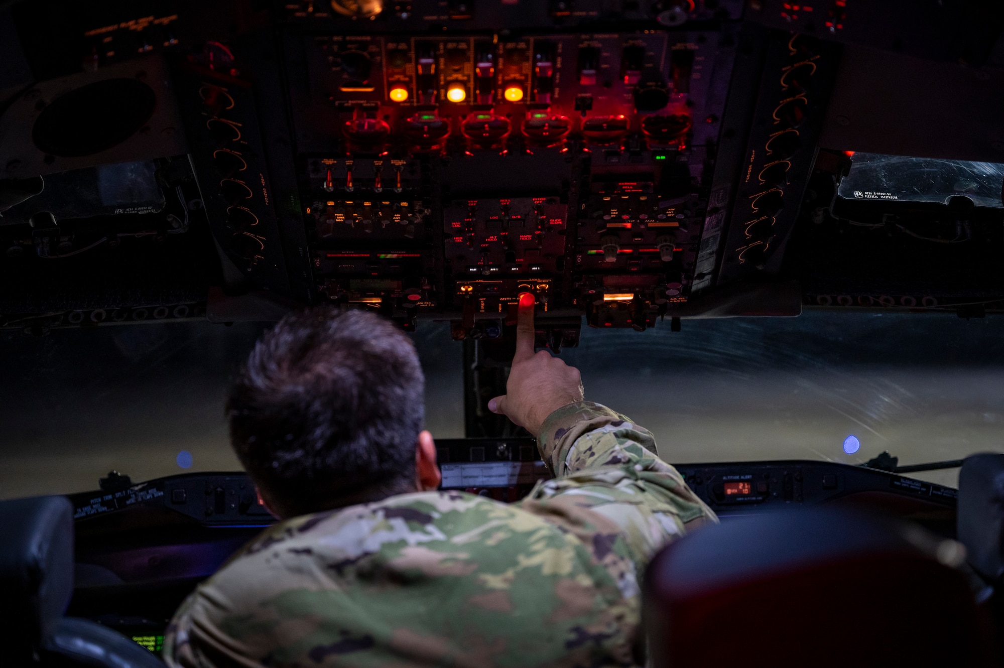 Pilot pressing switches on an aircraft